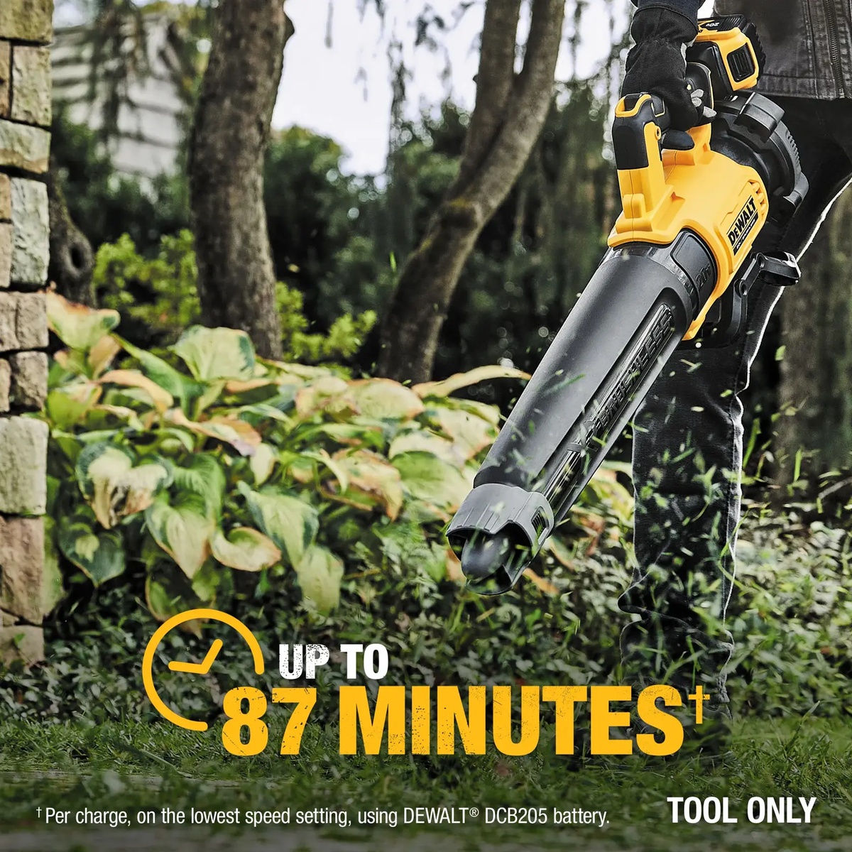 DEWALT 20V MAX XR Brushless Cordless Handheld Blower cleaning around a stone wall and planting bed where controlled airflow matters