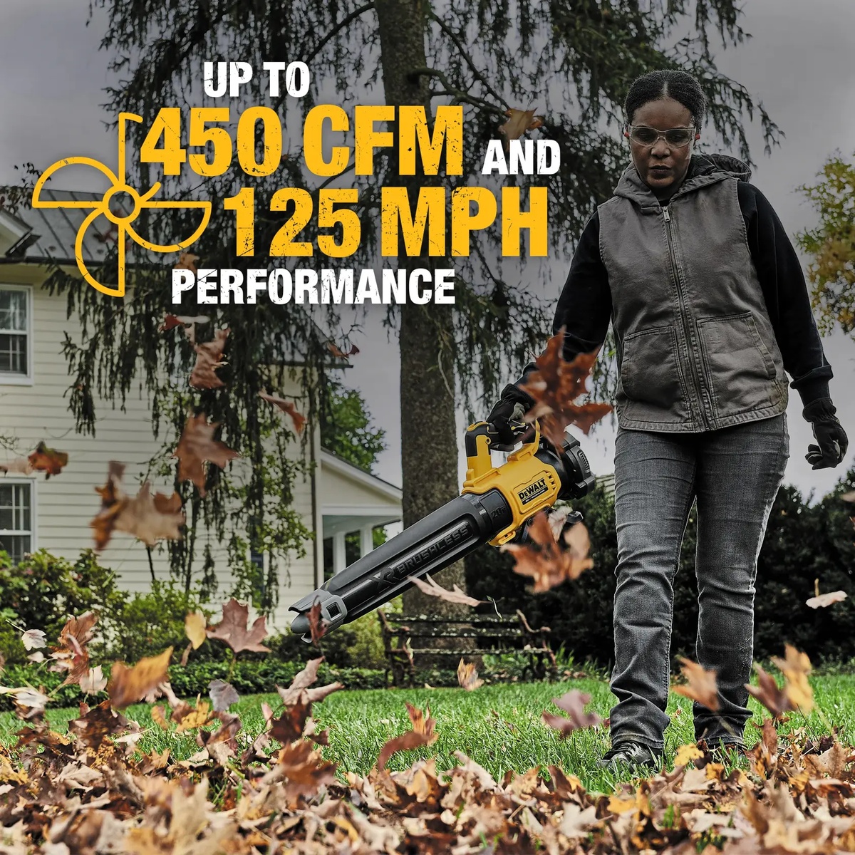 DEWALT 20V MAX XR Brushless Cordless Handheld Blower clearing dry leaves across a residential lawn edge and driveway area during outdoor cleanup