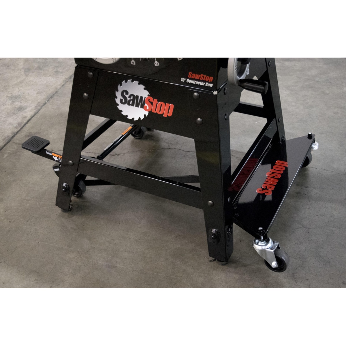 SawStop MB-CNS-000 Contractor Saw Mobile Base installed under a contractor table saw on a concrete shop floor showing caster placement and steel frame support