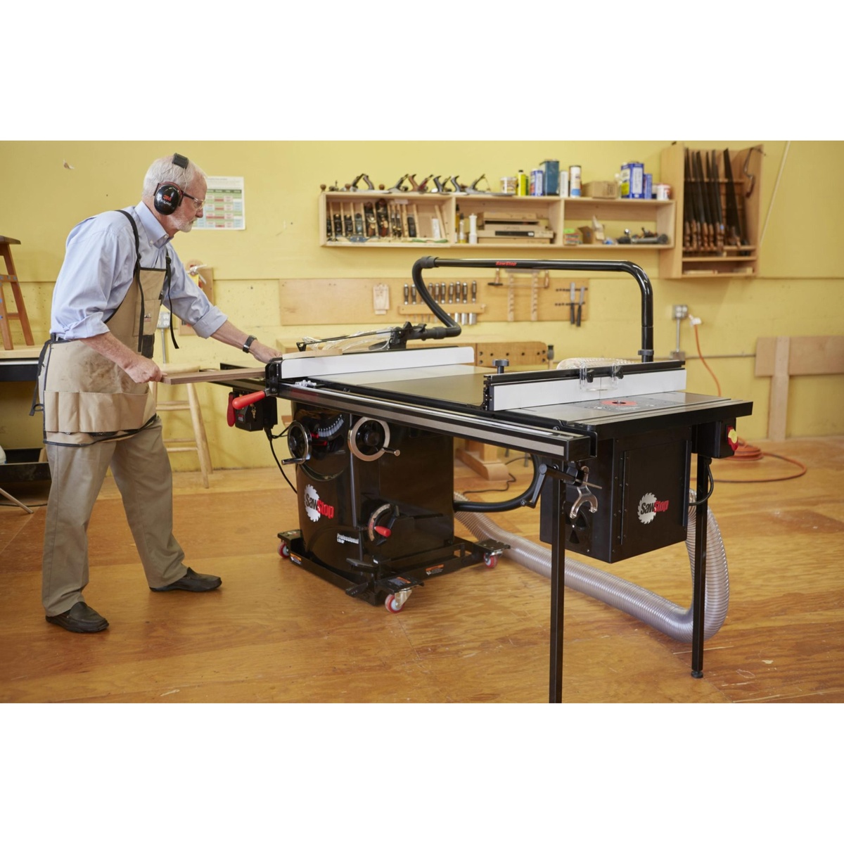 SawStop PCS175-PFA30 Professional Cabinet Saw in use ripping wood in a woodworking shop with dust collection connected