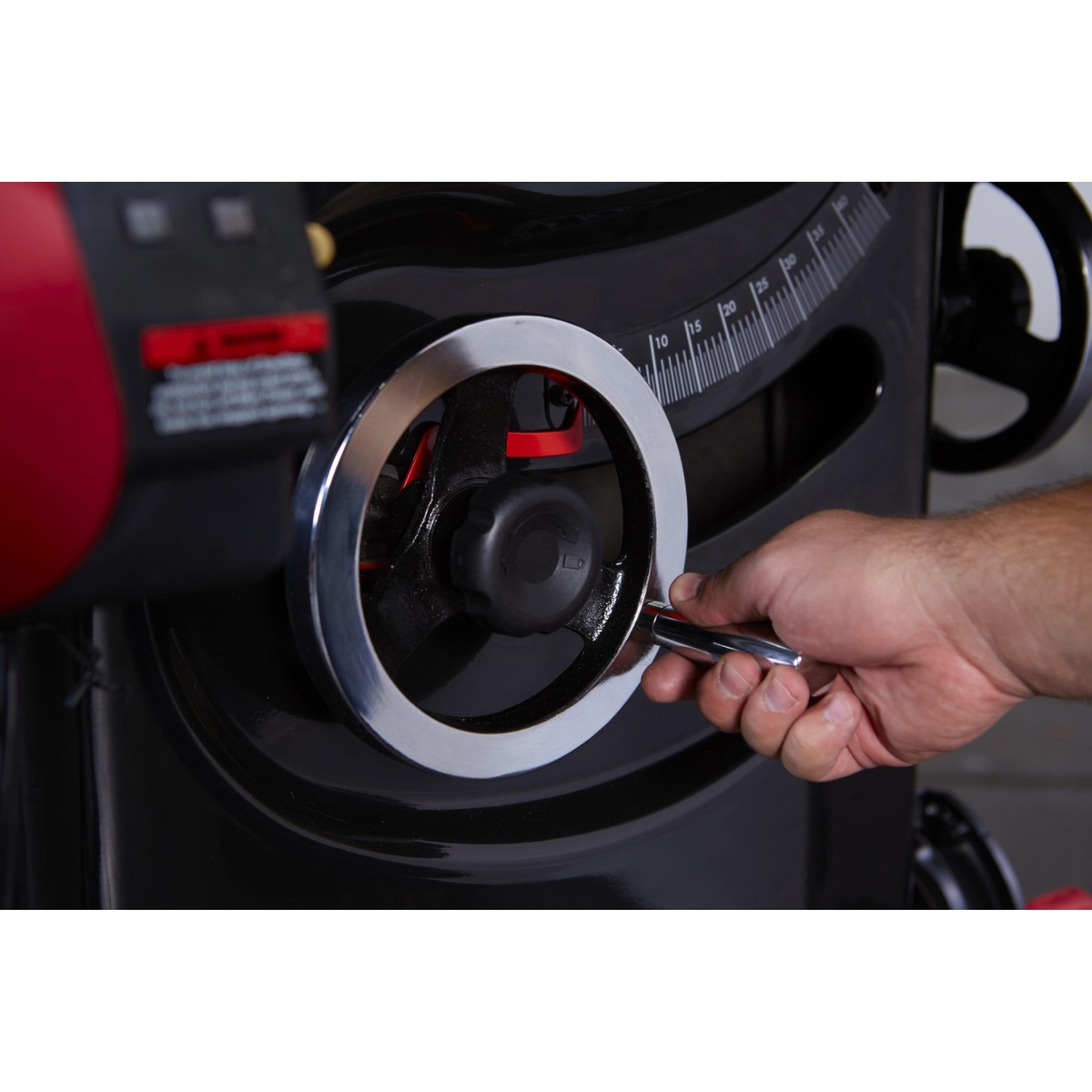 SawStop PCS31230-TGP236 Professional Cabinet Saw height and tilt handwheel being adjusted for blade setup on a cabinet saw in a woodworking shop