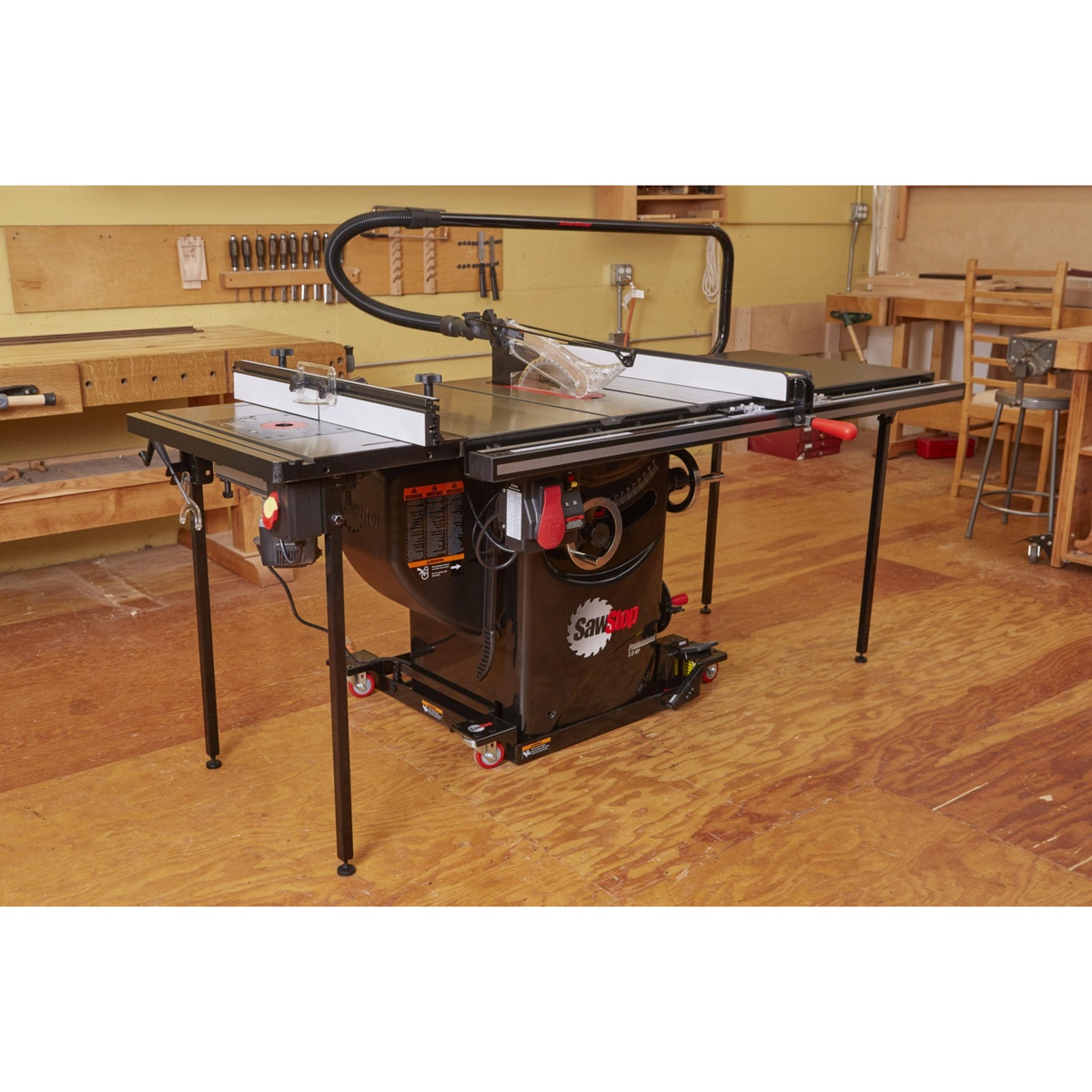 SawStop PCS31230-TGP236 Professional Cabinet Saw set up in a woodworking shop with overhead dust collection guard and T-Glide fence ready for ripping hardwood and sheet goods