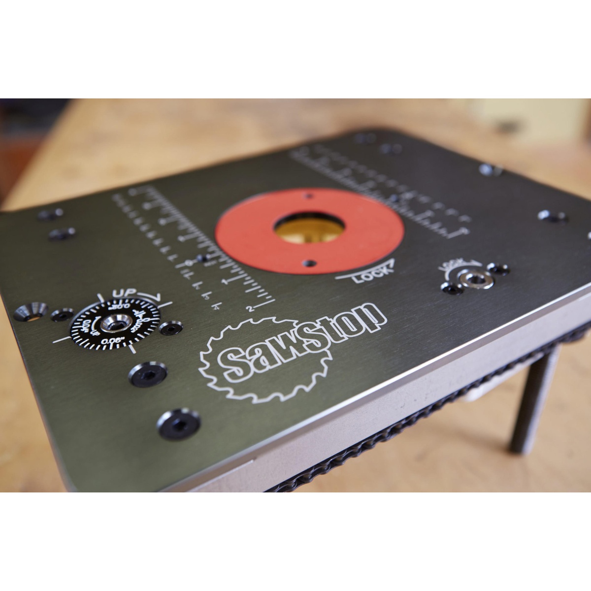 SawStop RT-LFT Four-Post Router Lift with Lock top plate with measurement markings and insert ring on a woodworking benchtop