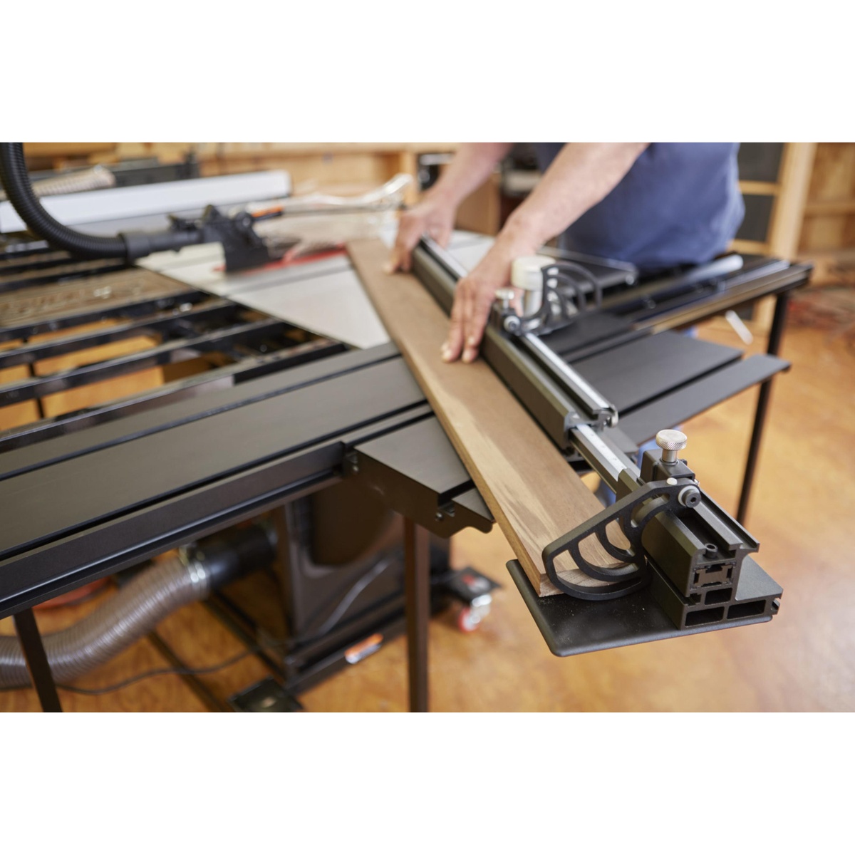 SawStop Sliding Crosscut Table guiding a wide wood panel across a table saw in a woodworking shop for accurate crosscutting