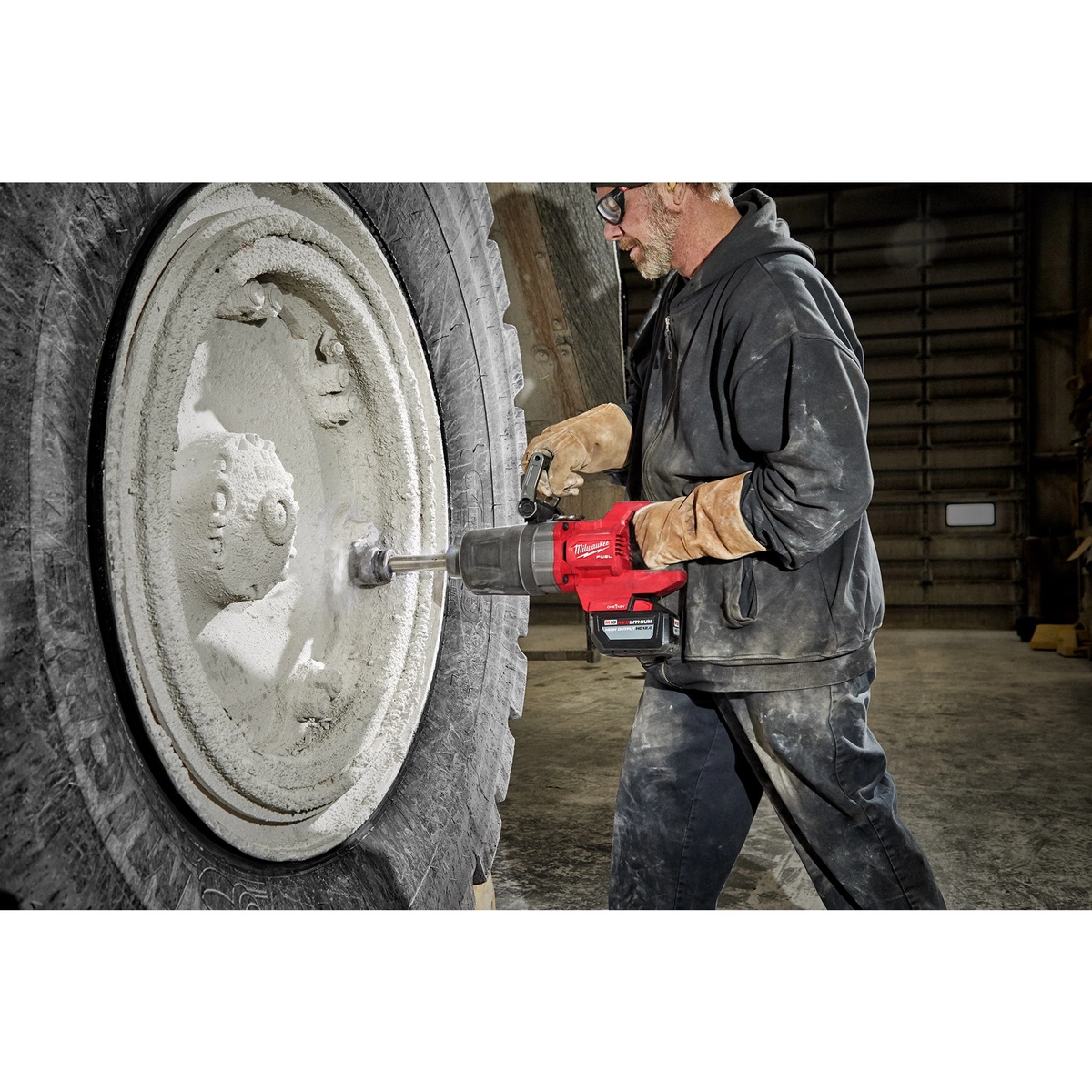Milwaukee 2869-20 M18 FUEL 1-Inch D-Handle Extended Anvil High Torque Impact Wrench with ONE-KEY removing a large lug nut on heavy equipment in a service bay