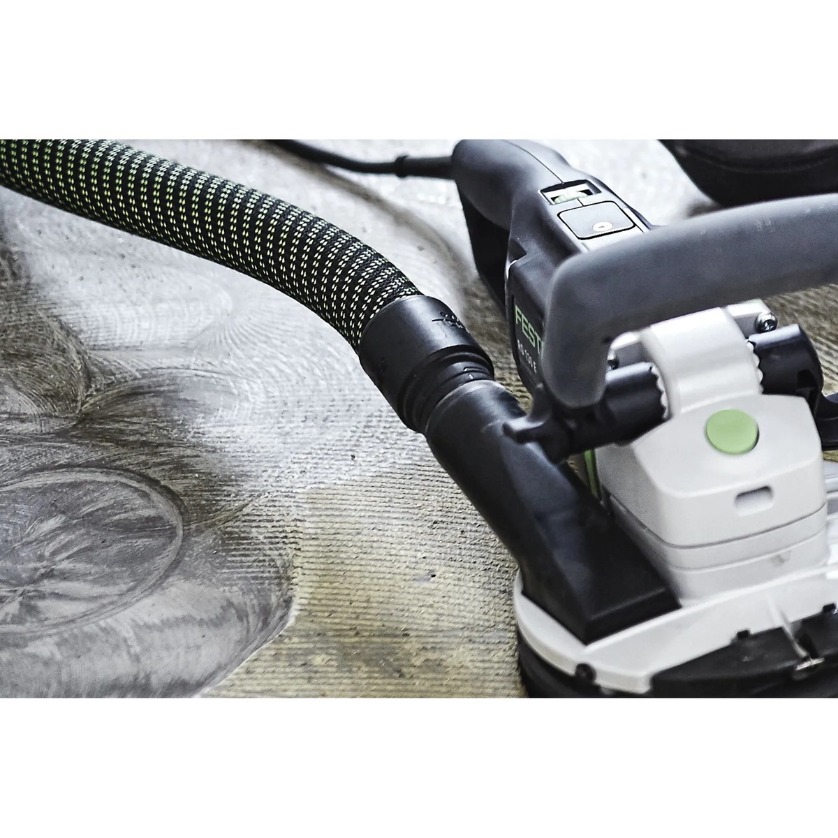Festool 204923 Anti-Static Suction Hose D36/32x3.5m attached to a surface grinder on masonry material, showing close-up hose routing during renovation dust extraction