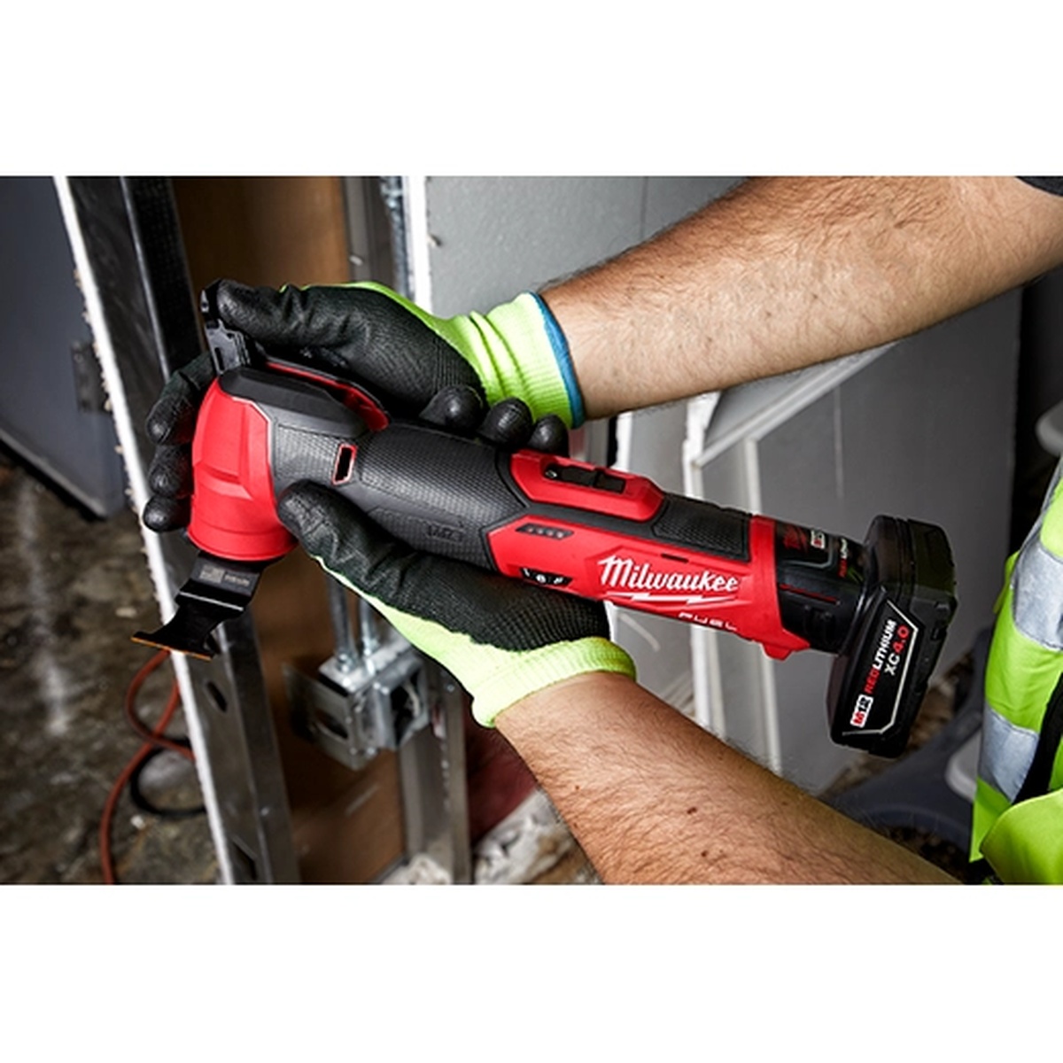 Milwaukee 2526-20 M12 FUEL Oscillating Multi-Tool being used in a framed interior opening for tight-space cutting and trimming work