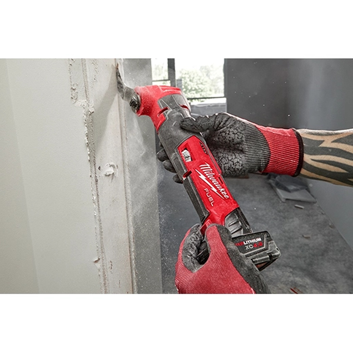 Milwaukee 2526-20 M12 FUEL Oscillating Multi-Tool making a flush cut in wall material during remodeling work