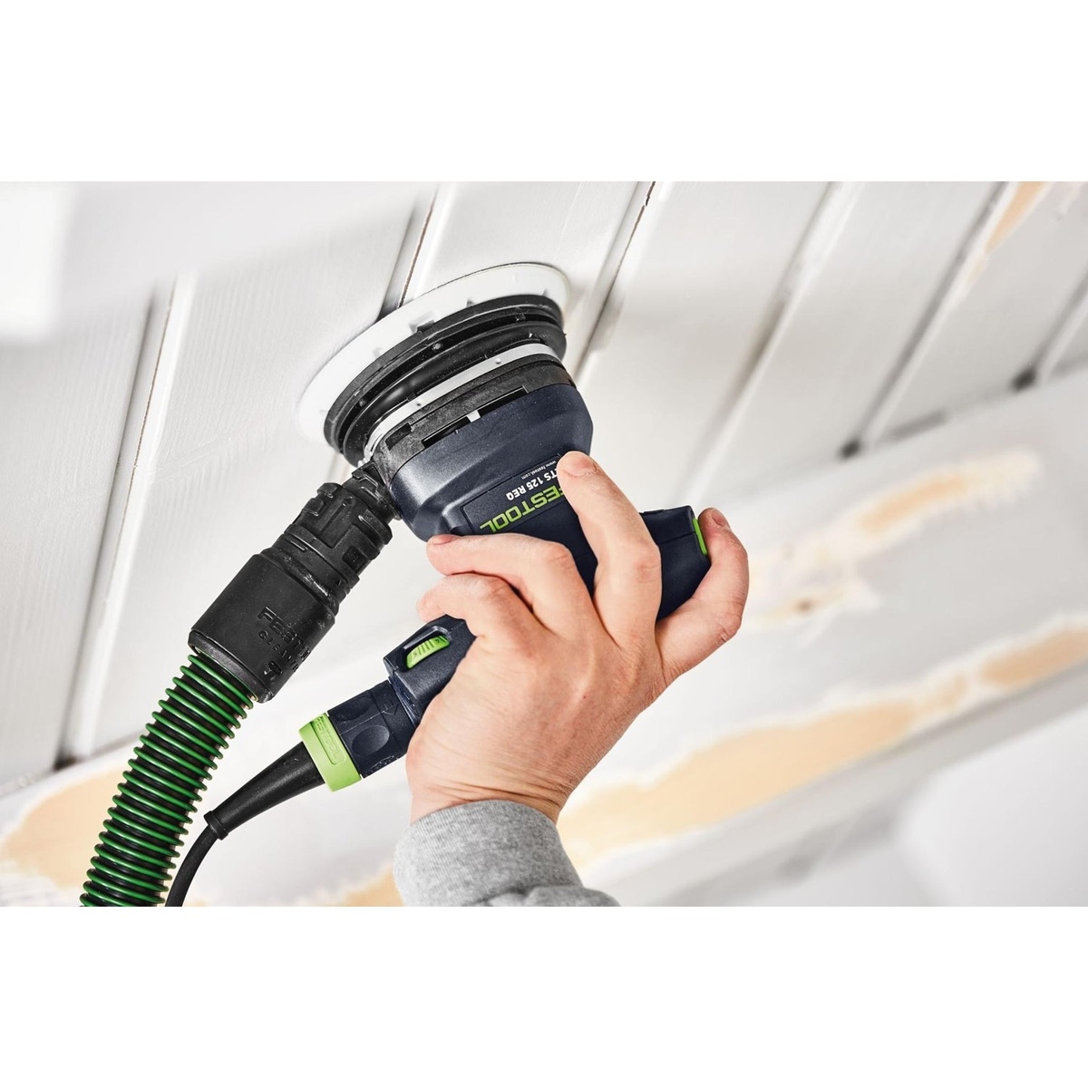 Festool ETS 125 REQ-Plus 125mm random orbital sander sanding an overhead painted panel with dust extraction connected during finish prep work