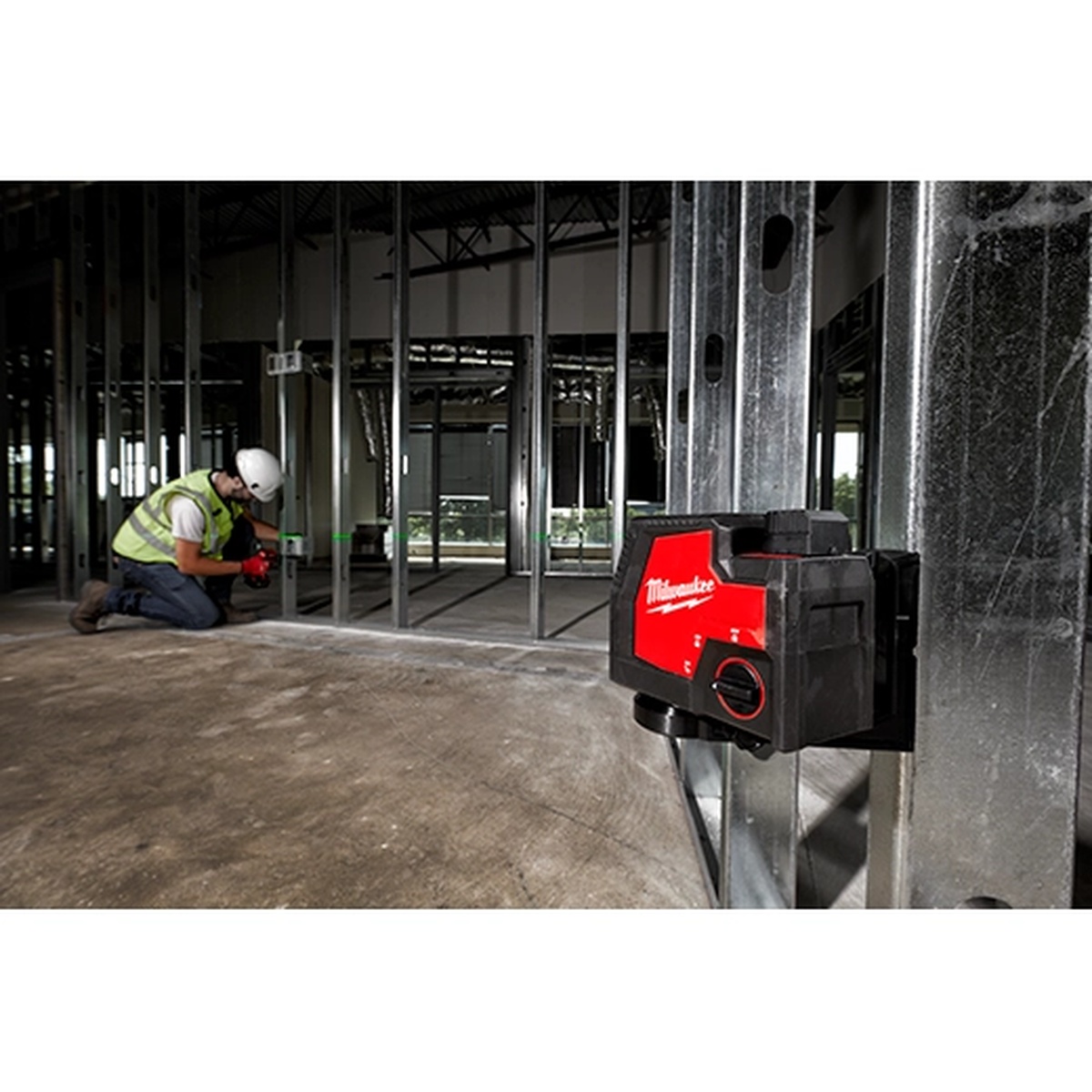 Milwaukee 3521-21 USB Rechargeable Green Cross Line Laser mounted to a metal stud with magnetic bracket during steel framing alignment work