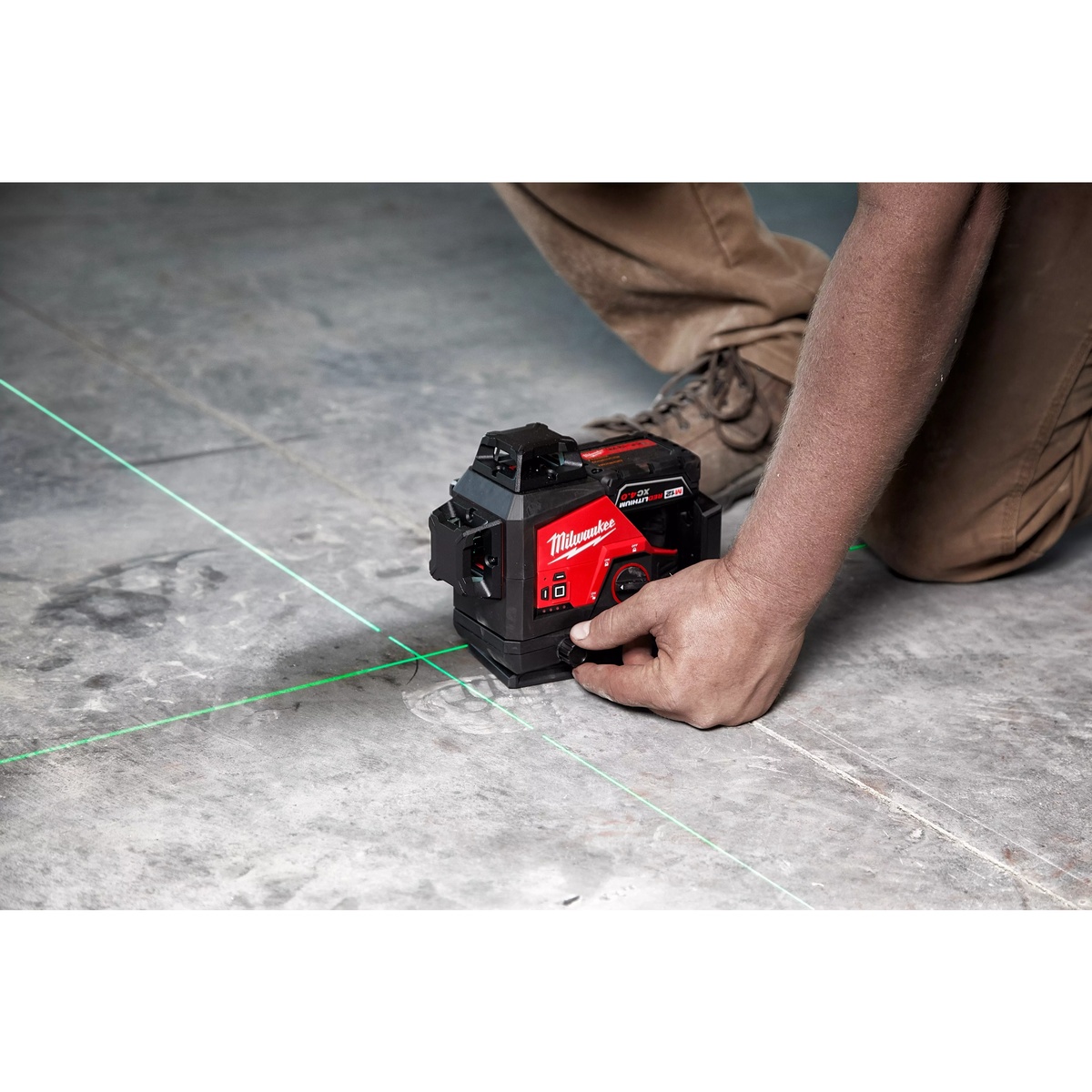 Milwaukee 3632-21 M12 Green 360 3-Plane Laser Kit projecting green laser lines across a concrete floor during interior layout work on a jobsite