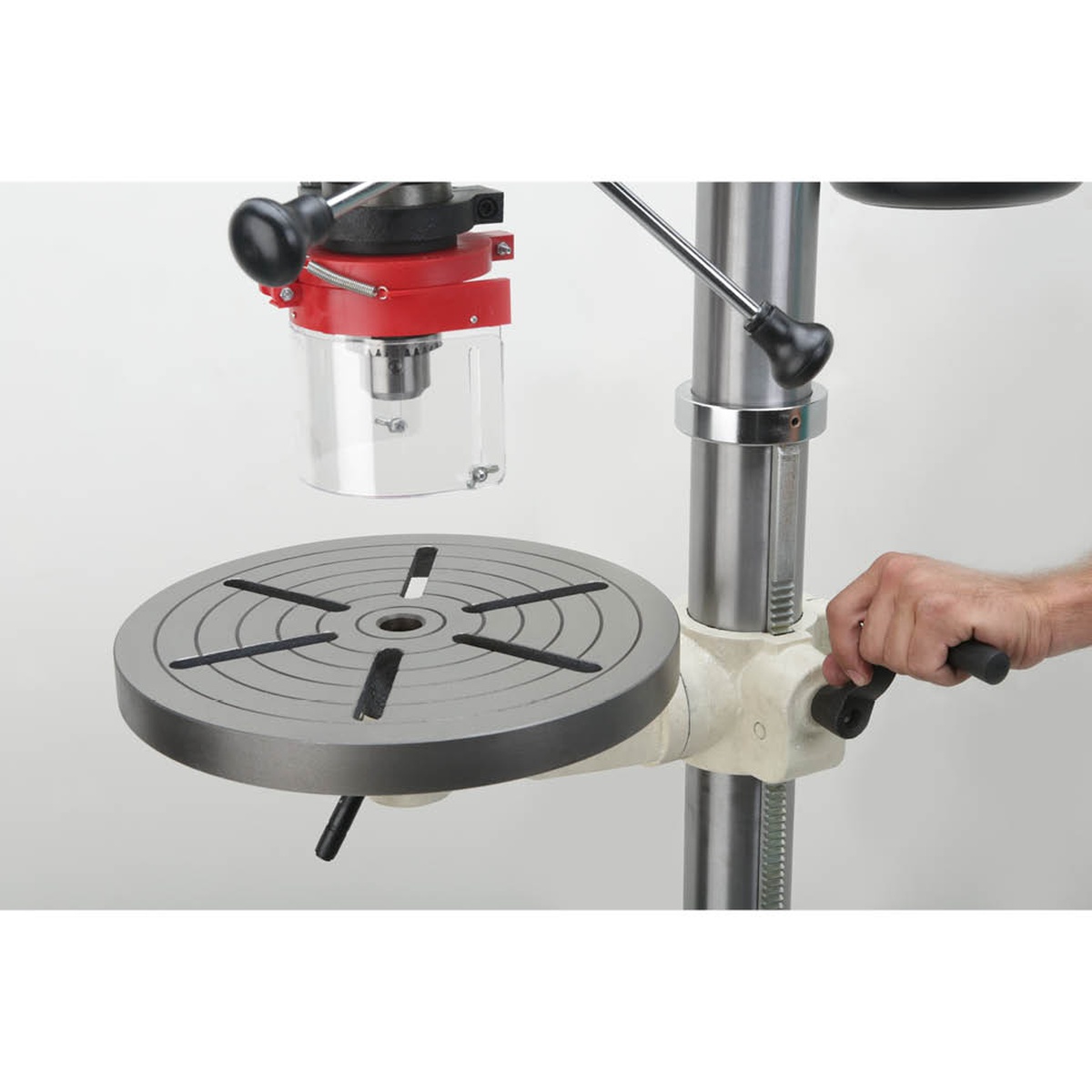 Shop Fox W1680 1 HP 17-Inch Floor Model Drill Press table adjustment area showing the round cast iron table and crank for positioning work in a woodworking or metalworking shop