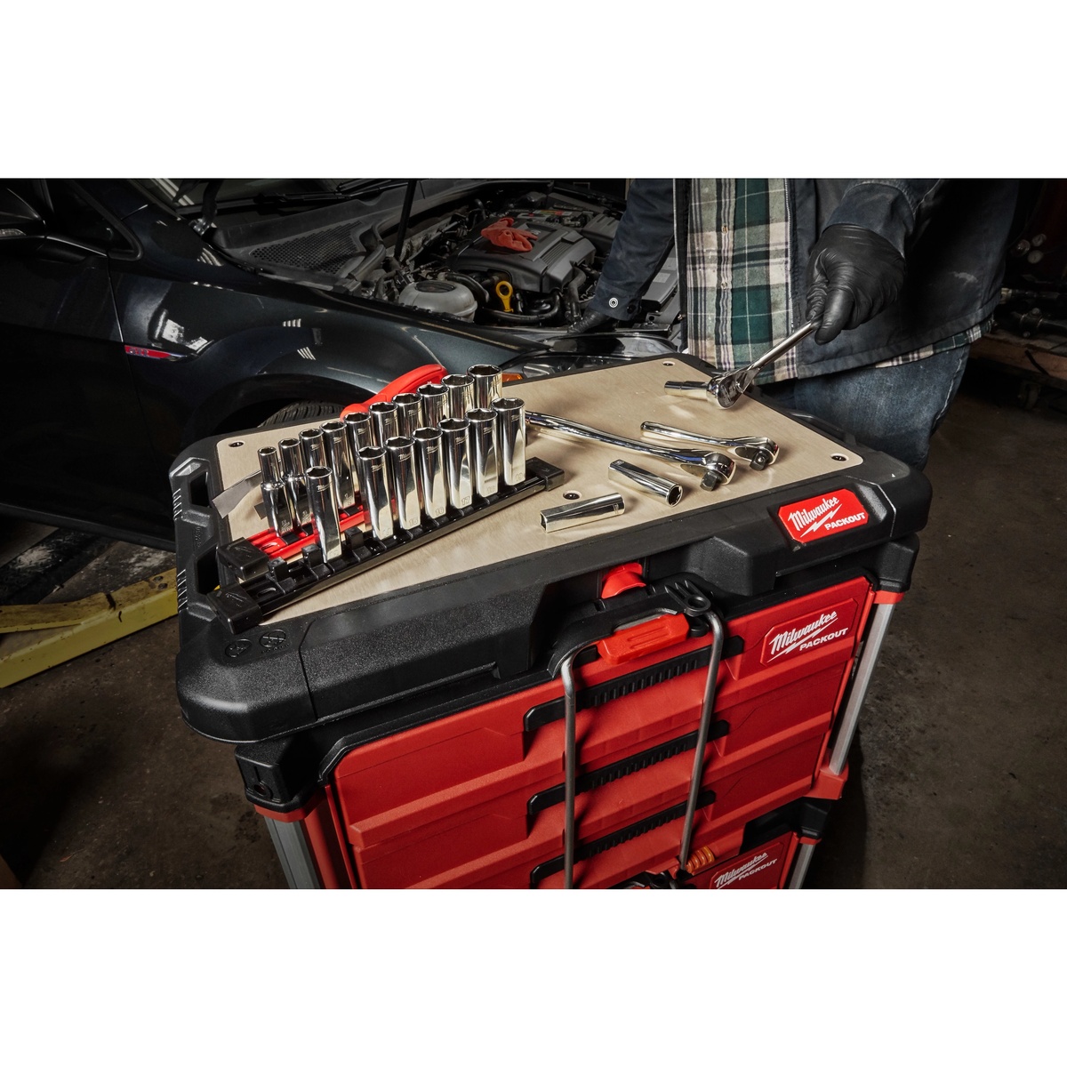 Milwaukee 48-22-8488 PACKOUT Customizable Work Top used as a socket and ratchet staging surface on a PACKOUT drawer stack in an automotive repair bay