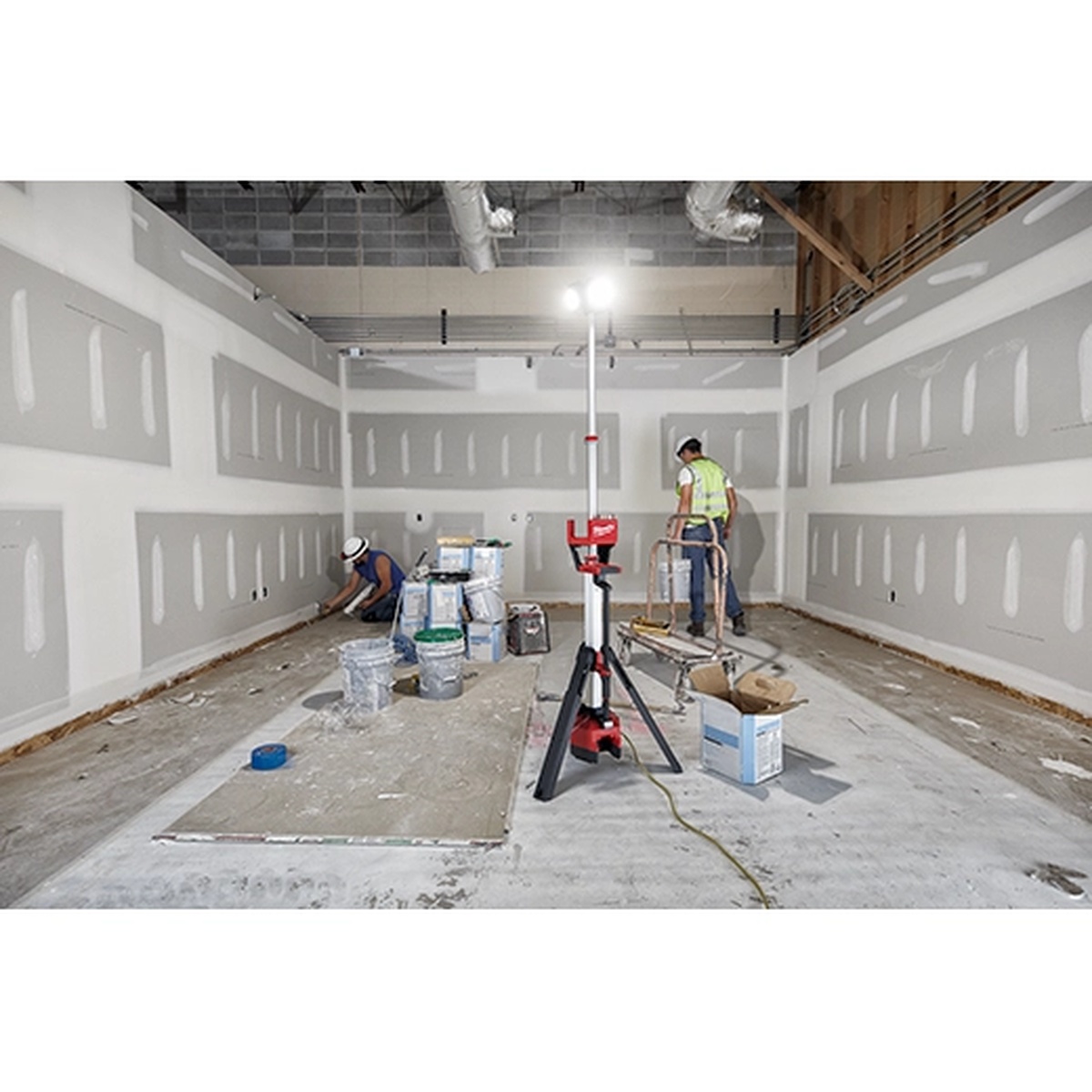 Milwaukee 2136-20 M18 ROCKET Tower Light/Charger lighting an unfinished interior room during drywall and renovation work