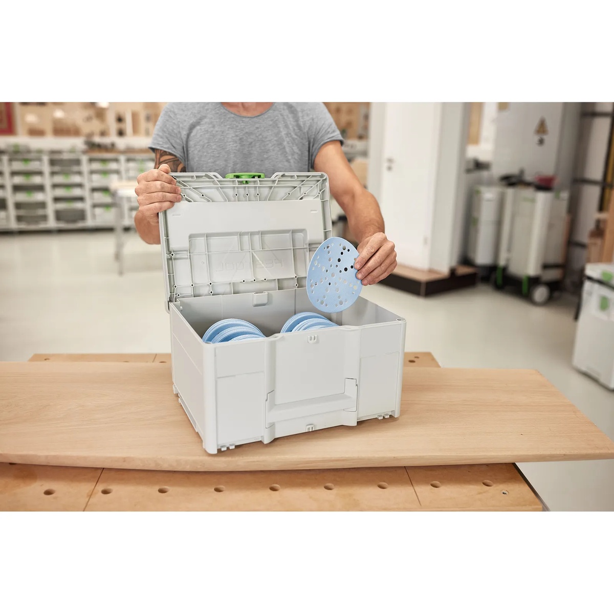 Festool 576785 Systainer3 SYS-STF D150 open on a workbench with 6-inch sanding discs being organized in a woodworking shop