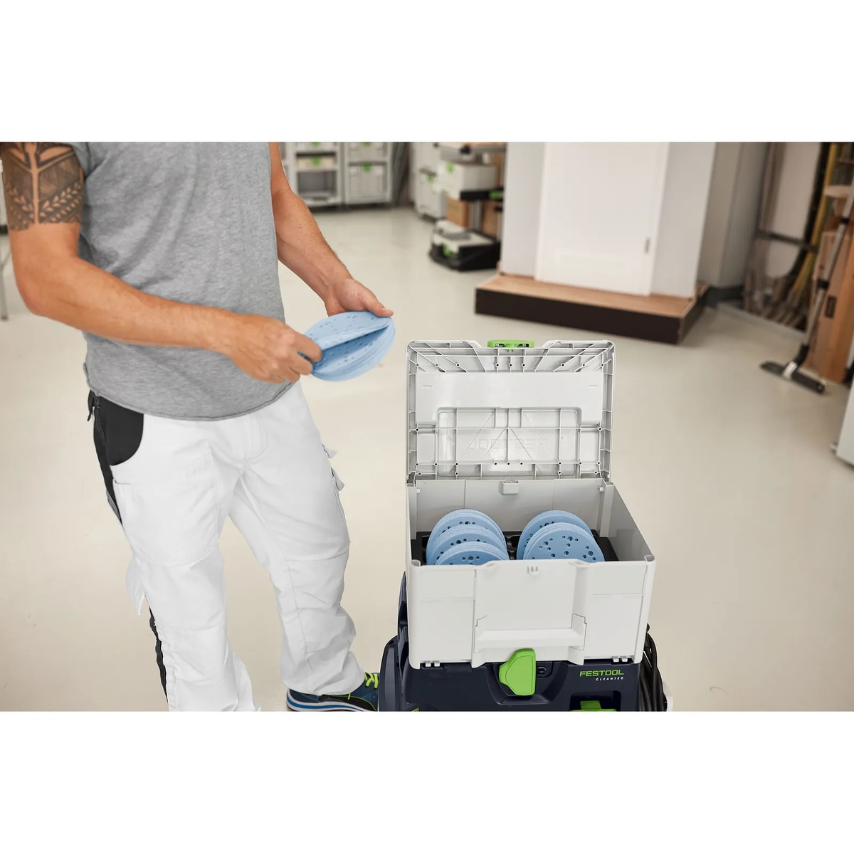 Festool 576785 Systainer3 SYS-STF D150 stacked on a Festool dust extractor cart with sanding discs in a workshop