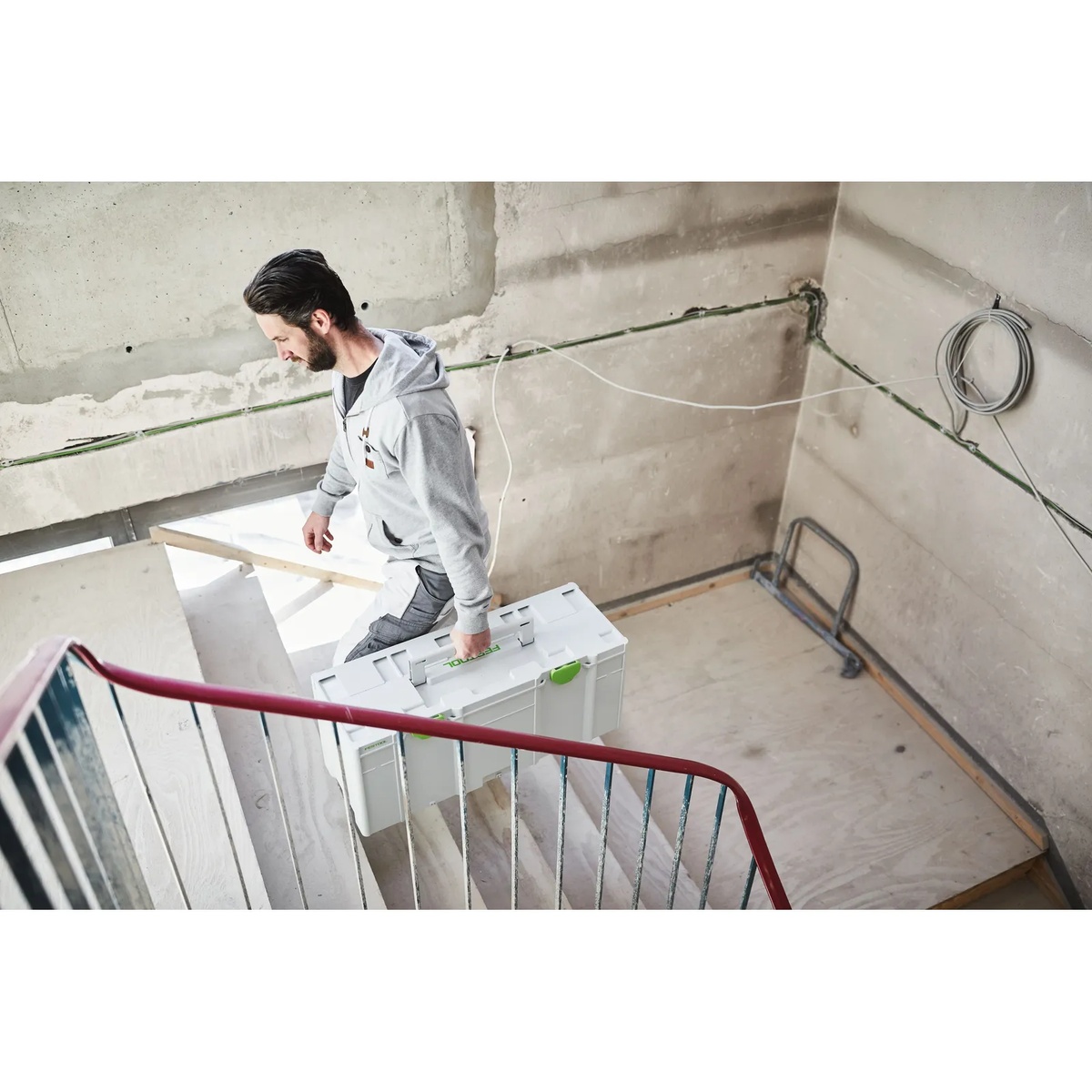 Festool 204851 Systainer3 XXL 337 carried up a stairwell on a construction site for organized transport of tools and equipment