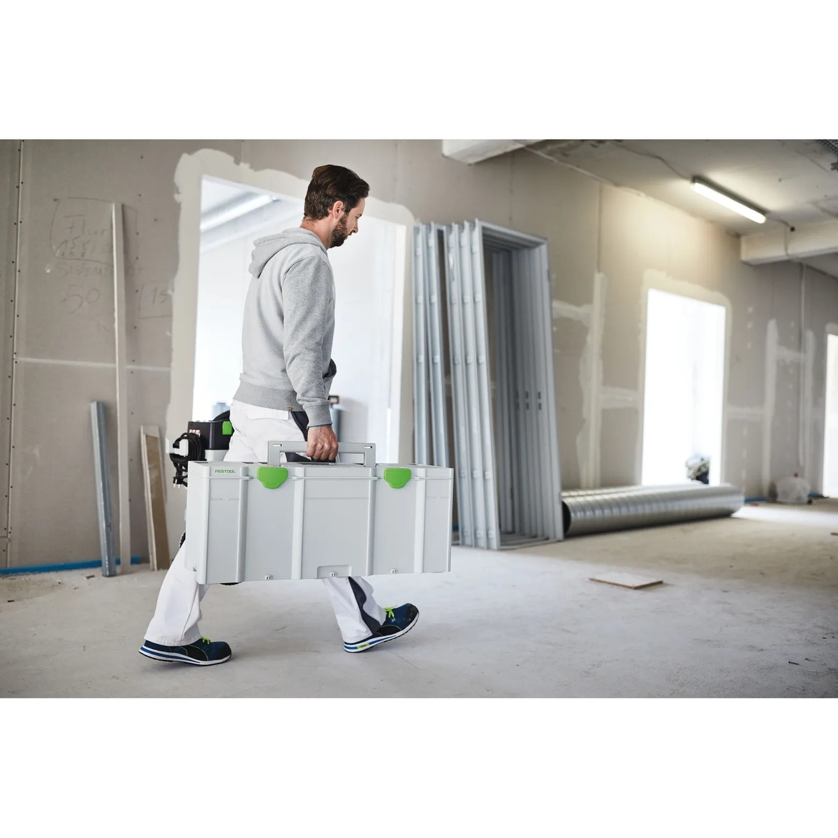 Festool 204851 Systainer3 XXL 337 being carried through an unfinished interior jobsite to transport tools and supplies between work areas