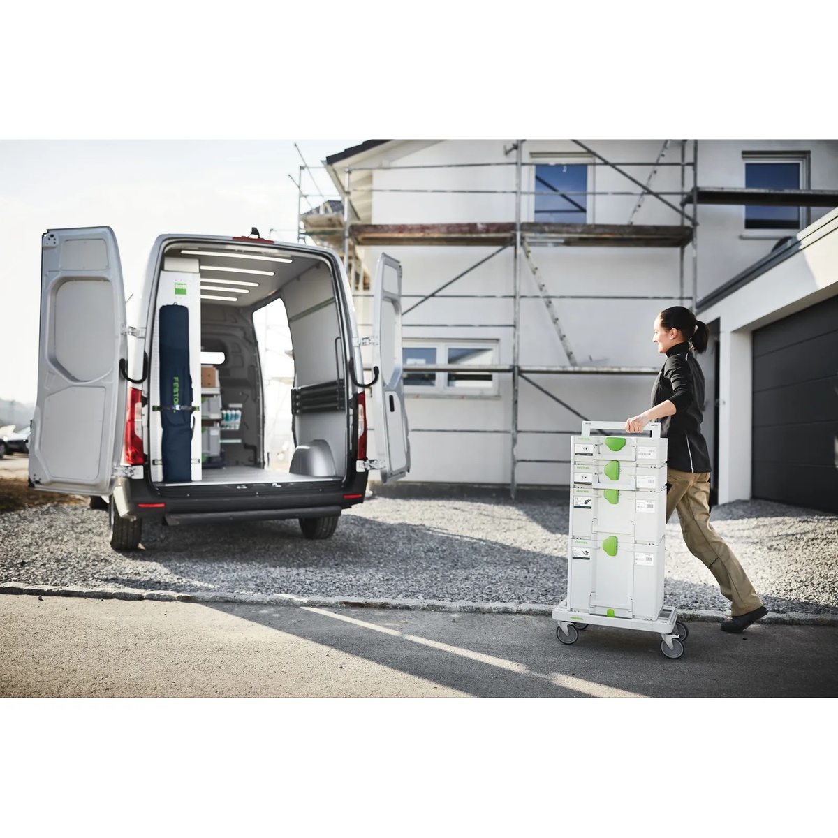 Festool SYS-RB Systainer Roll Board transporting a stacked column of Systainer cases from a work van to a residential jobsite