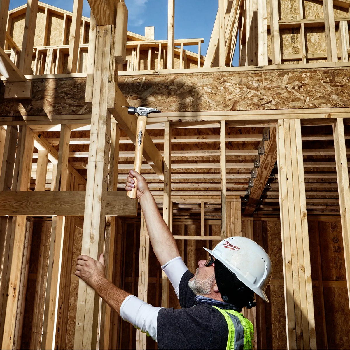 Stiletto TI14MC 14 oz Titanium Milled Face Hammer being used overhead during wood framing on a residential jobsite