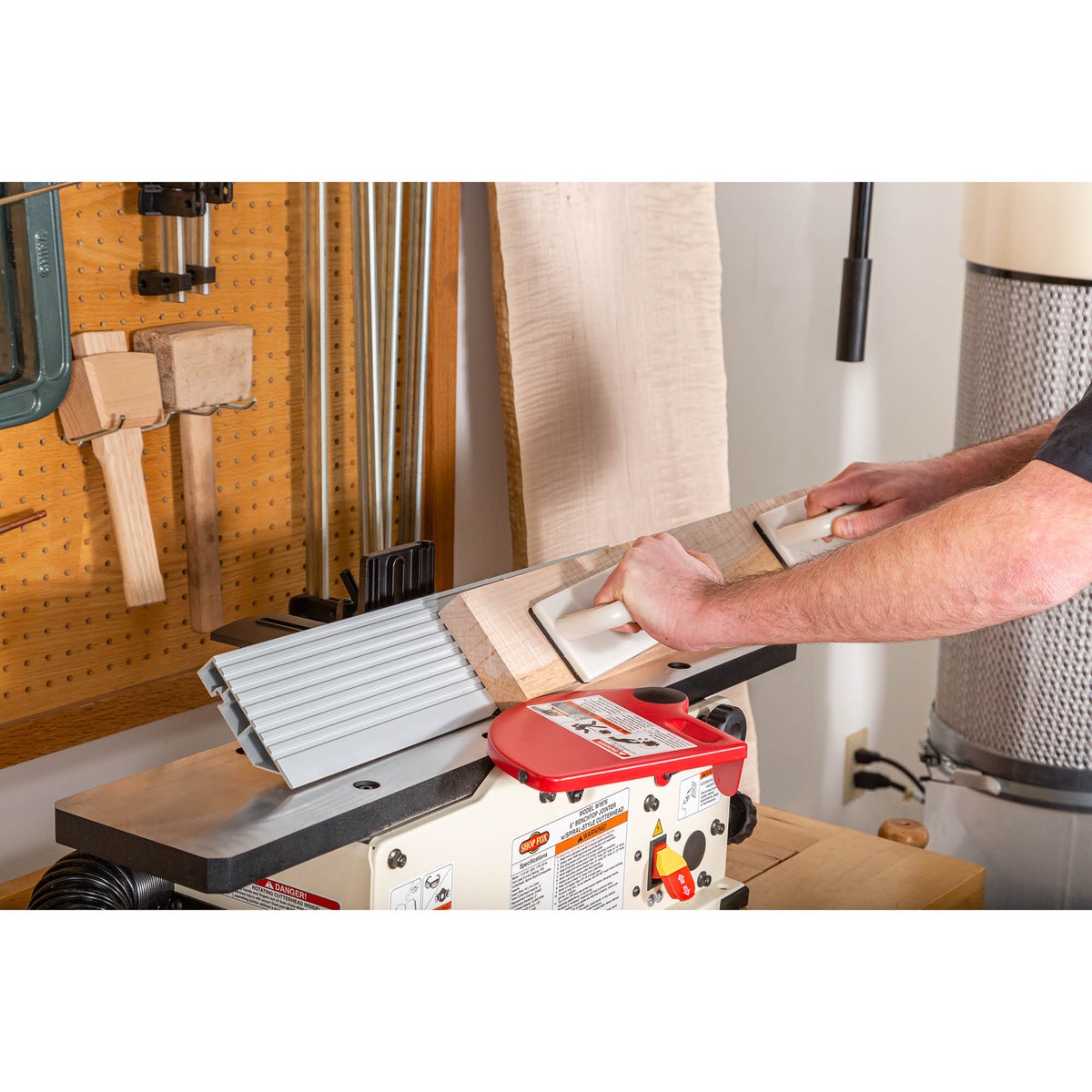 Shop Fox W1876 6-Inch Benchtop Jointer jointing a wood board on a workbench with push blocks in a woodworking shop