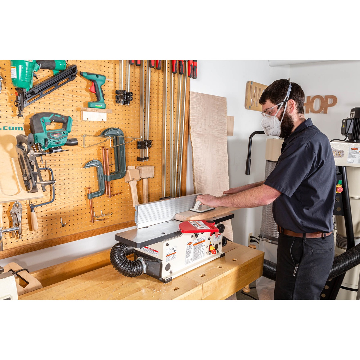 Shop Fox W1876 6-Inch Benchtop Jointer set up on a woodworking bench in a small shop for edge jointing boards