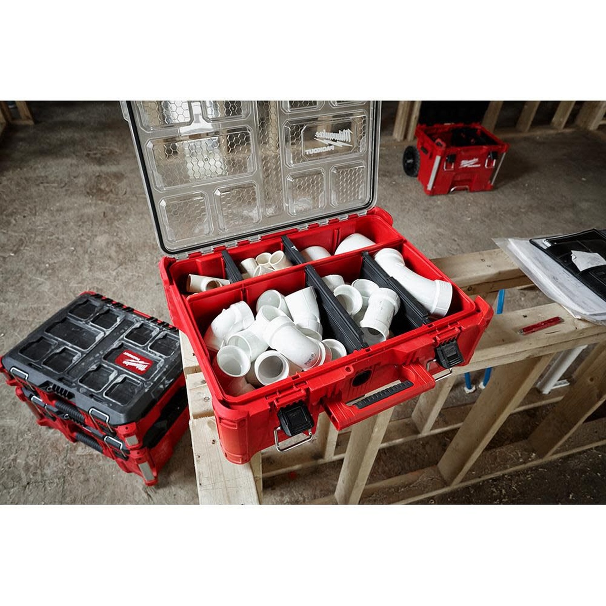 Milwaukee 48-22-8432 PACKOUT Deep Organizer opened on a framed jobsite holding plumbing fittings and parts on a workbench