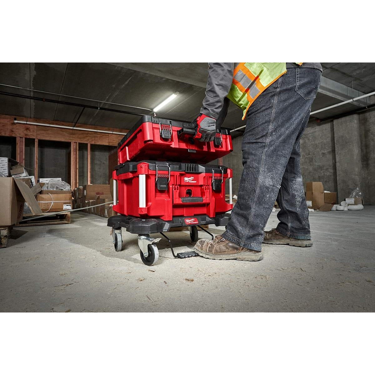 Milwaukee PACKOUT XL Tool Box and Dolly Cart Discount Pack being loaded on a jobsite floor with stacked PACKOUT storage boxes during tool transport