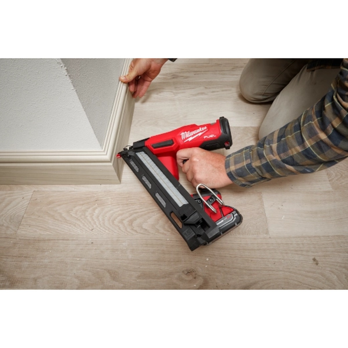 Milwaukee 2839-20 M18 FUEL 15 Gauge Finish Nailer installing baseboard trim on a finished floor during interior remodeling work