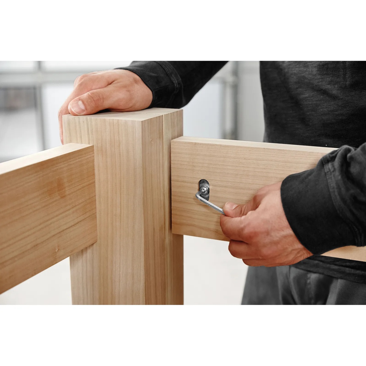 Festool 576795 Domino Connectors D14 for Domino XL being tightened with a hex wrench on a wood furniture joint at final installation