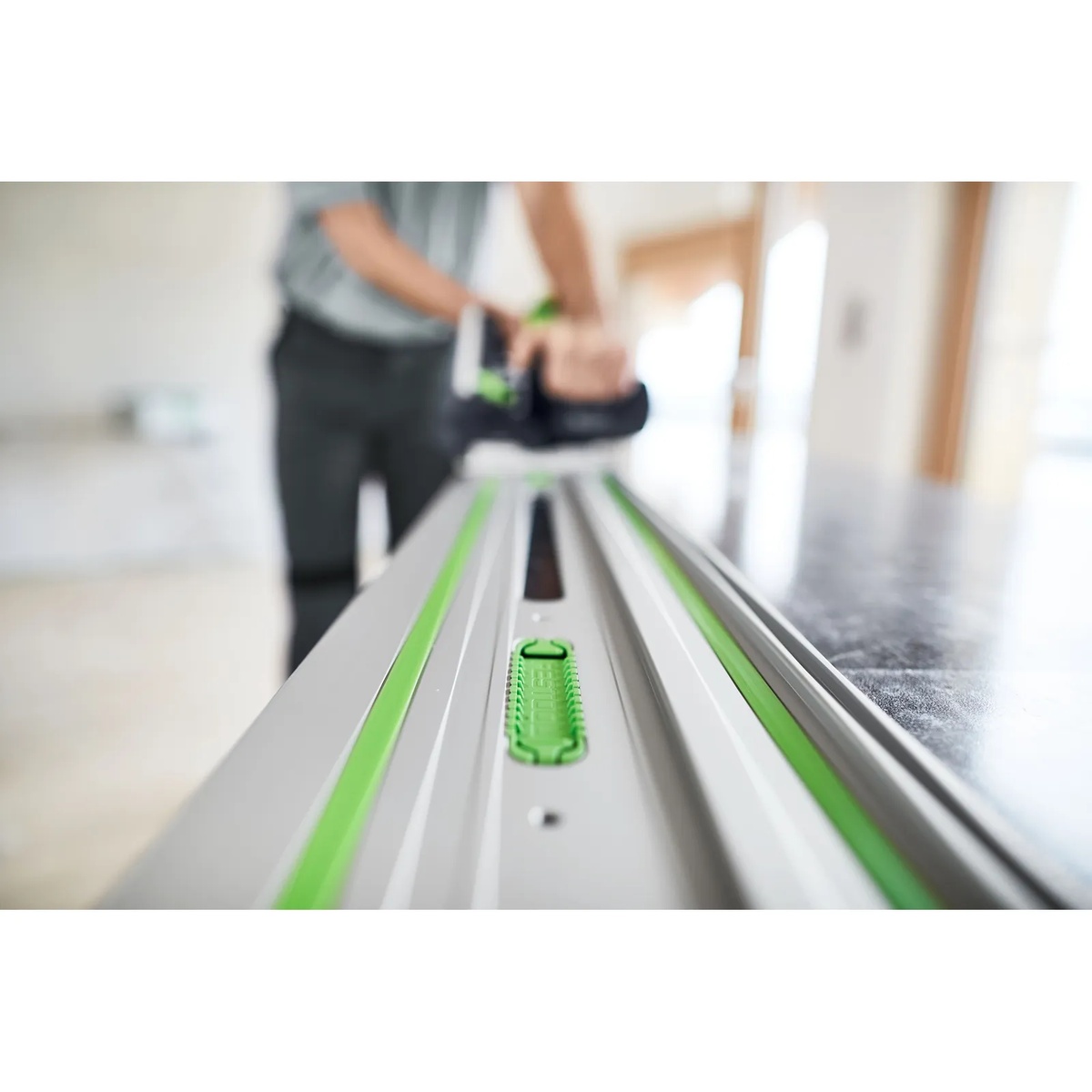 Close-up of the Festool 577044 75-in Guide Rail, FS 1900/2-KP with adhesive pad installed while a saw runs along the rail during interior finish work