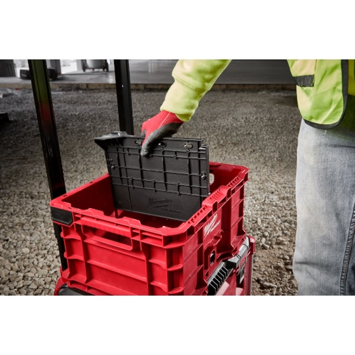 Milwaukee Divider for PACKOUT Crate being installed into a PACKOUT crate on a jobsite to separate tools and materials