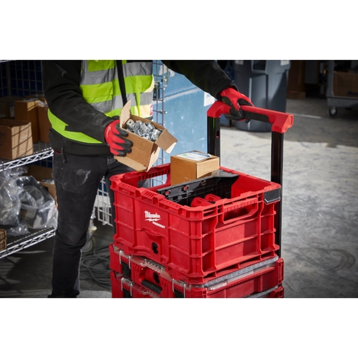 Milwaukee Divider for PACKOUT Crate installed inside a rolling PACKOUT crate holding tools and hardware in a workshop setting