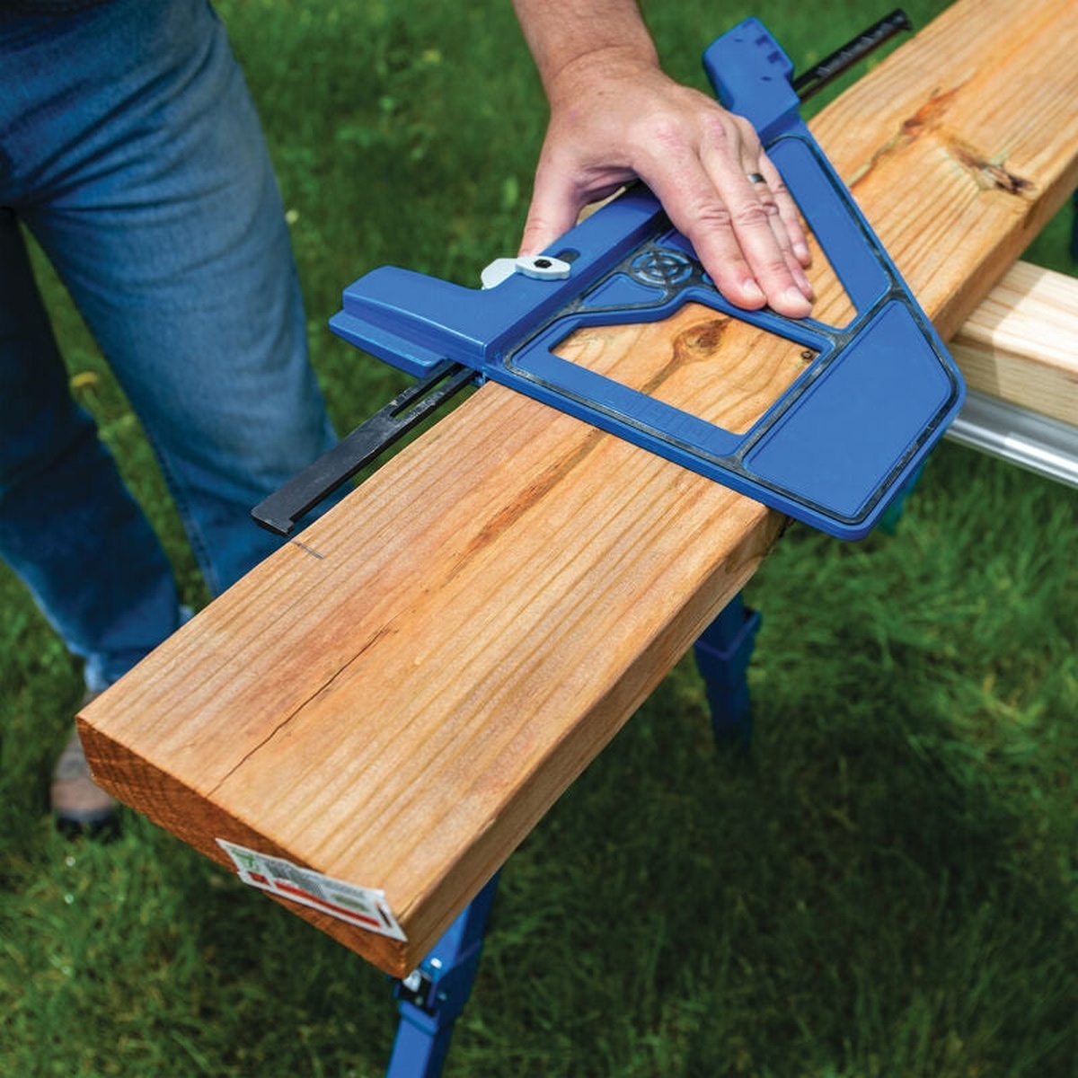 Kreg KMA4000-E Kreg Portable Circular Saw Crosscut Jig aligned to a pencil mark on a board for a quick crosscut outdoors