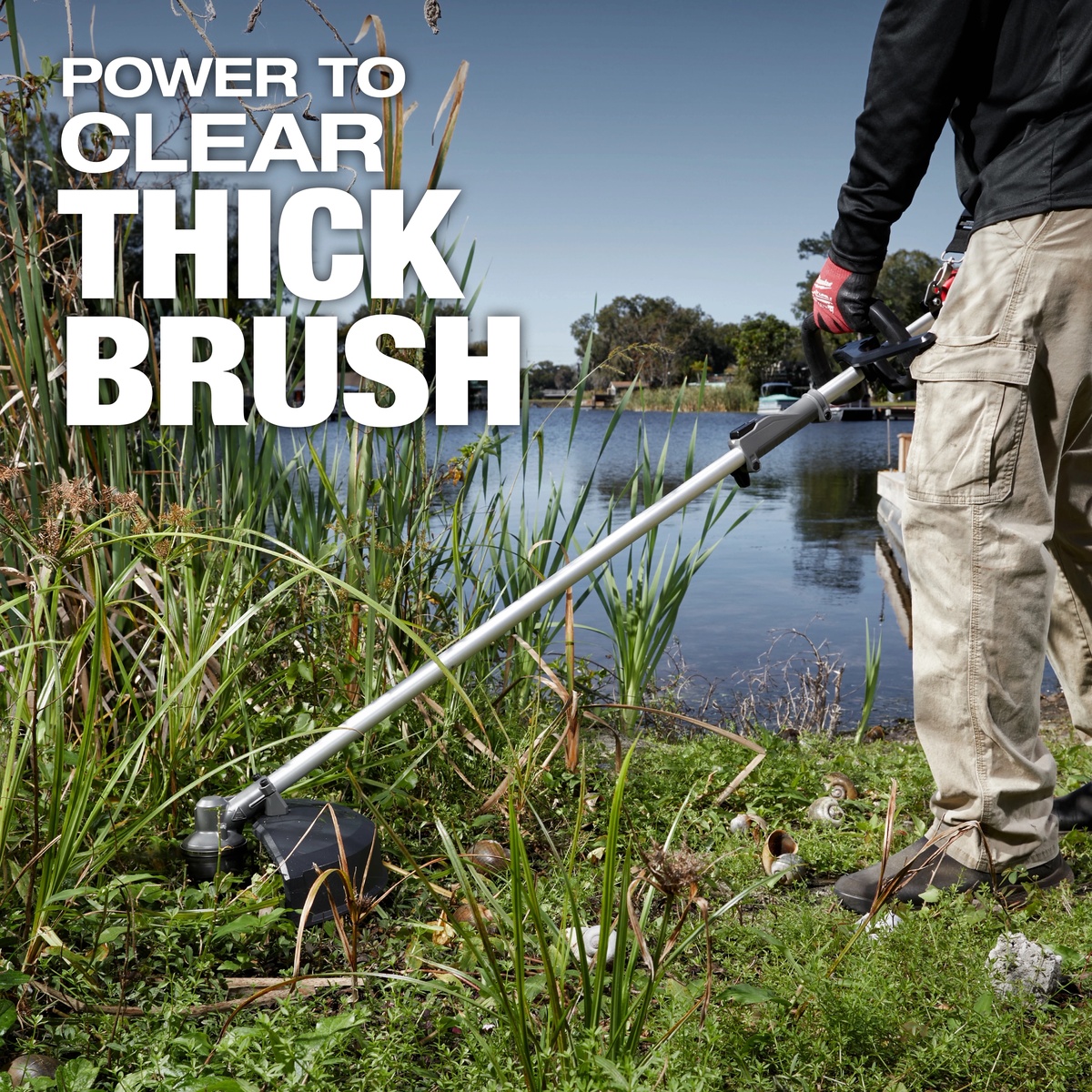 Milwaukee 49-16-2738 M18 FUEL QUIK-LOK Brush Cutter Attachment clearing thick brush and shoreline overgrowth in a real outdoor property maintenance setting