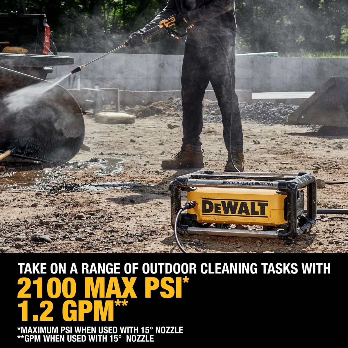 DEWALT 2100 PSI 1.2 GPM Electric Jobsite Pressure Washer cleaning equipment on a dusty outdoor jobsite with the washer set on the ground during active use