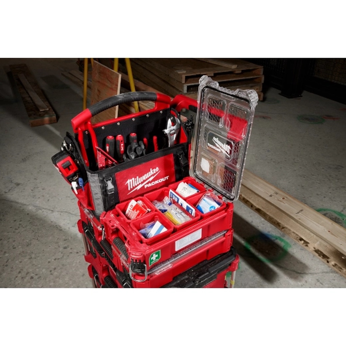 Milwaukee 48-73-8435C 79PC Class A Type III PACKOUT First Aid Kit mounted in a PACKOUT stack on a jobsite floor with tools and lumber nearby