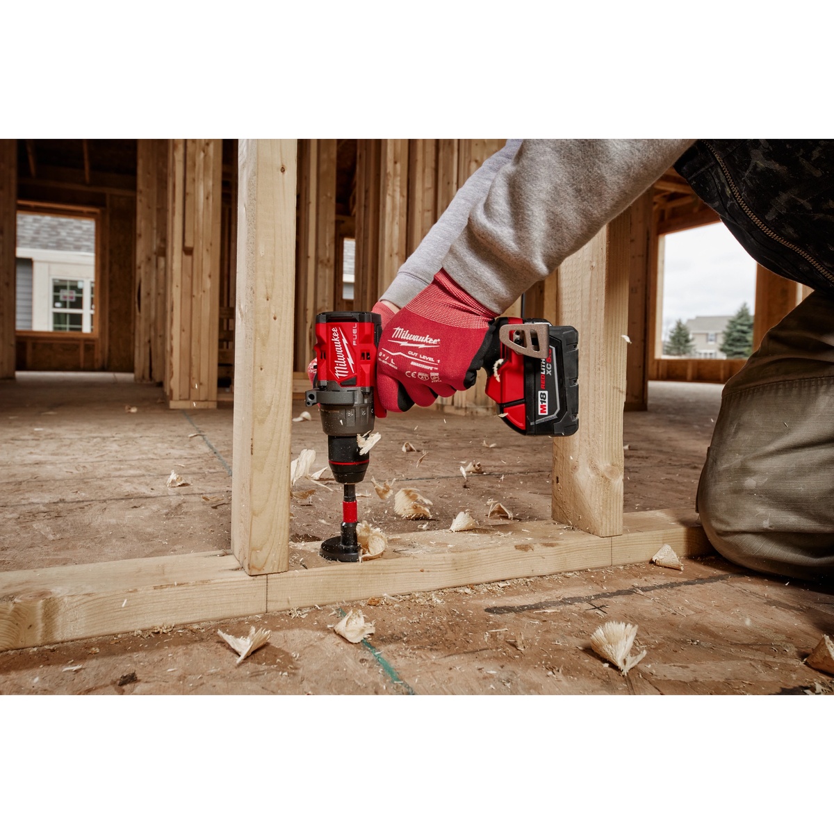 Milwaukee 2904-22 M18 FUEL 1/2-in. Hammer Drill/Driver Kit boring a large hole through framing lumber on a residential jobsite