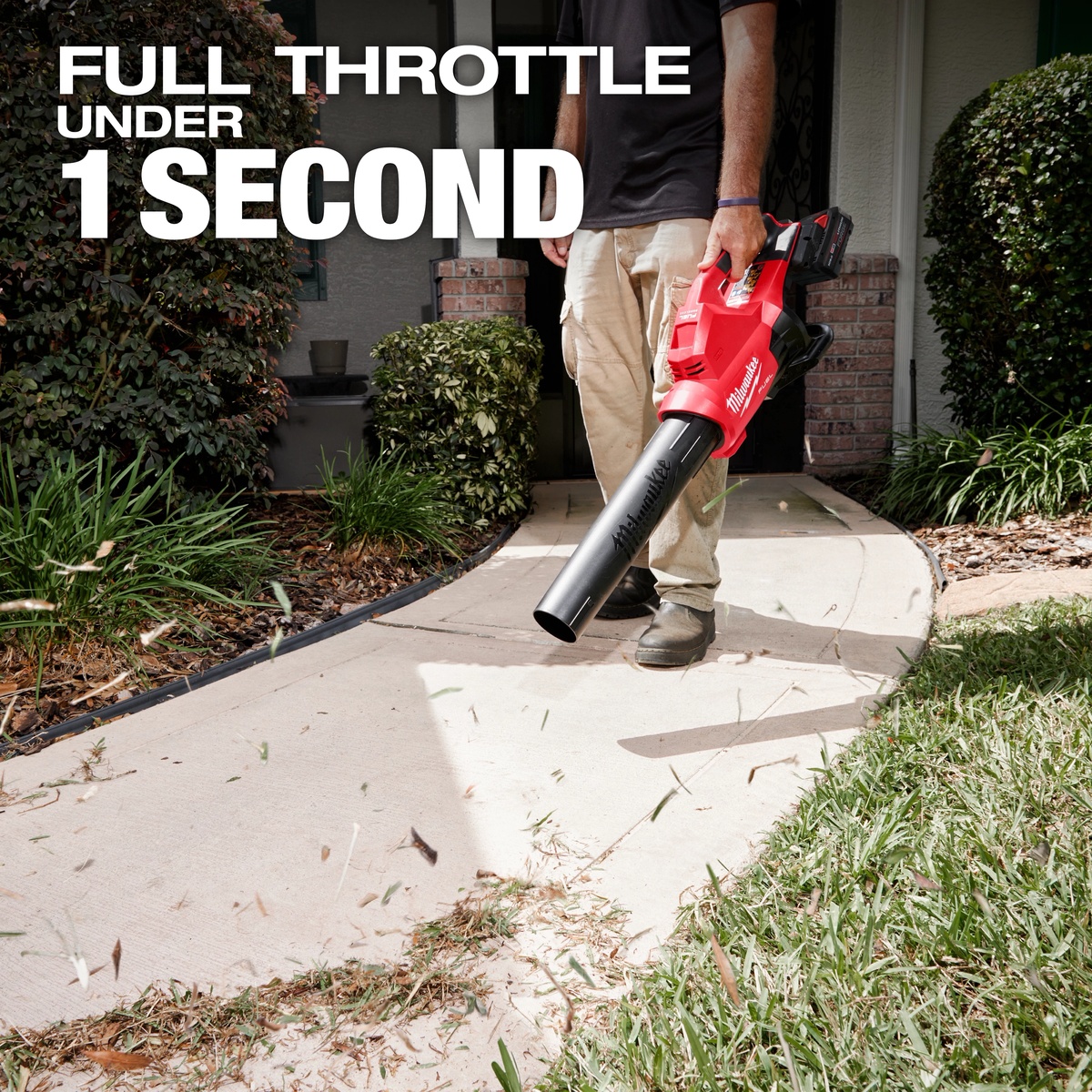 Milwaukee M18 FUEL Dual Battery Blower being carried and used along a residential walkway for fast debris clearing