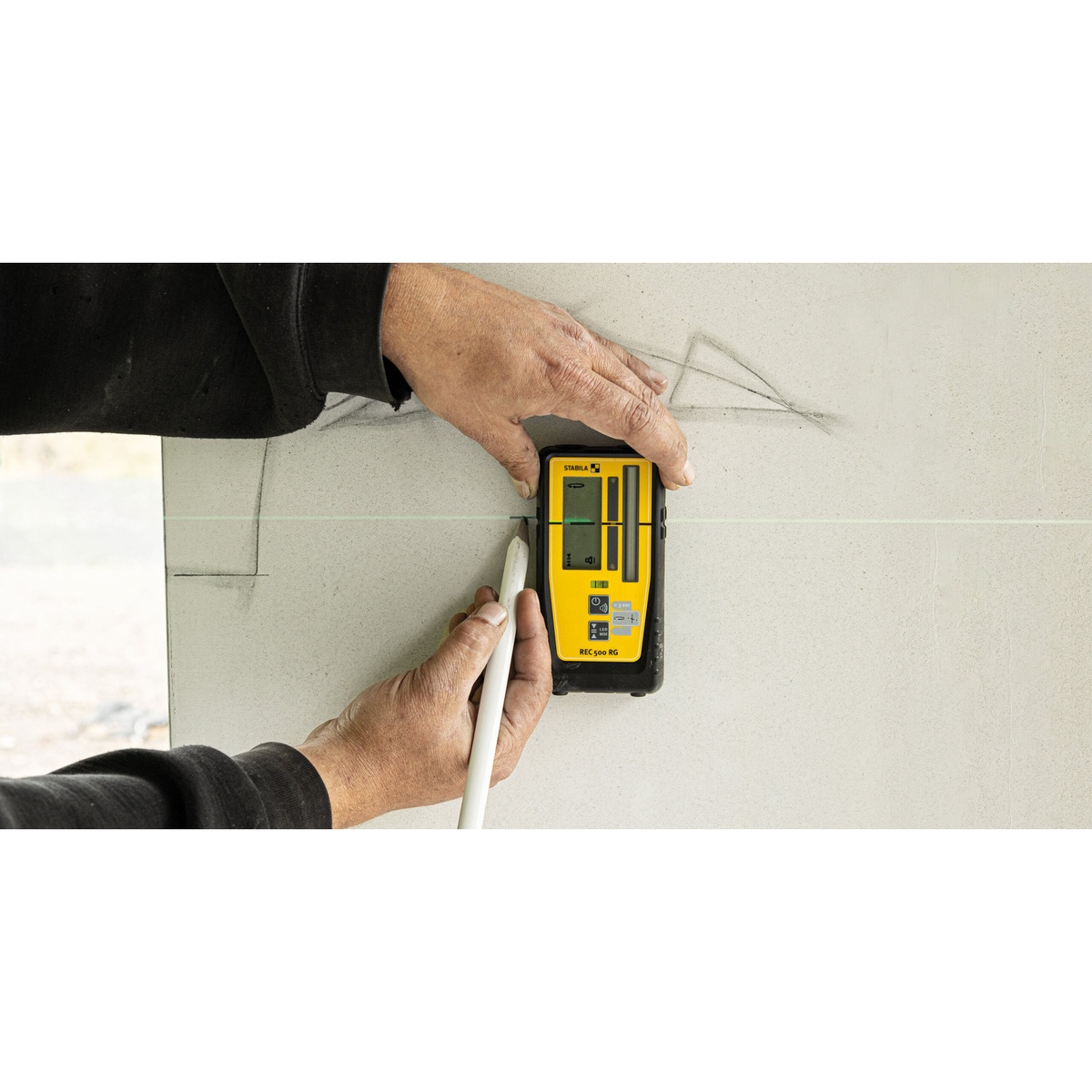 Stabila REC 500 RG Universal Rotary and Line Laser Receiver being used on a wall layout task with a visible laser line during indoor marking work
