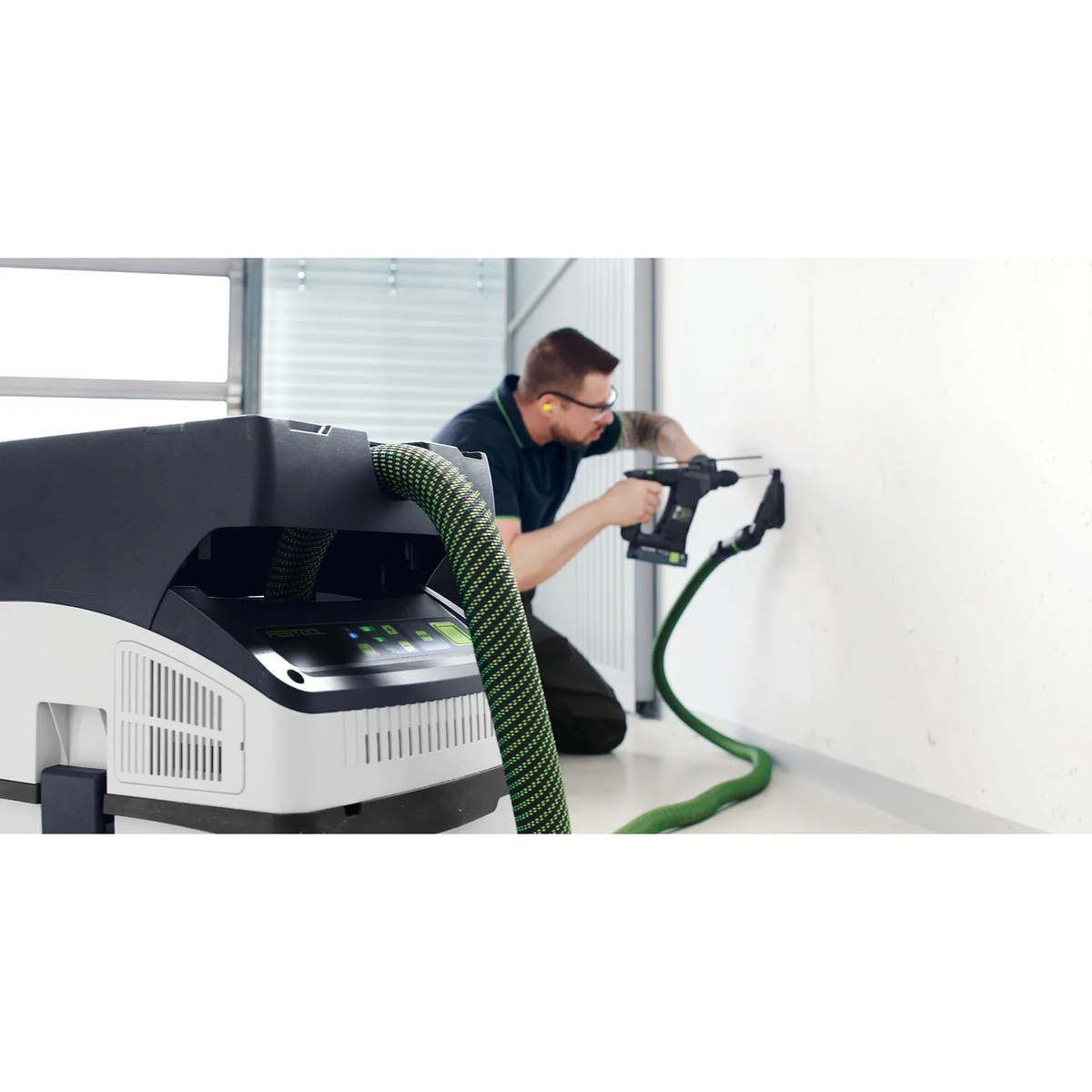 Festool cordless HEPA dust extractor paired with a cordless drilling application for wall work in a clean interior setting
