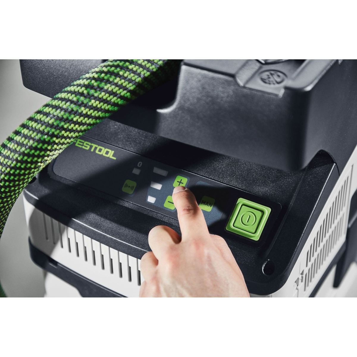 Festool cordless dust extractor control panel adjusting suction power for sanding and drilling dust collection in close-up