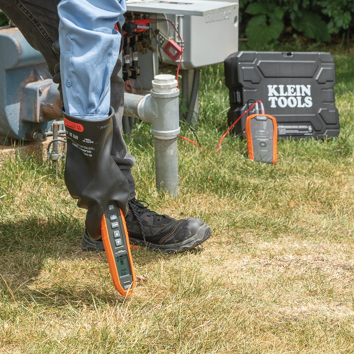 Klein Tools ET450 Advanced Electrical Circuit Breaker Finder and Wire Tracer Kit and Case tracing an underground wire path near outdoor electrical equipment