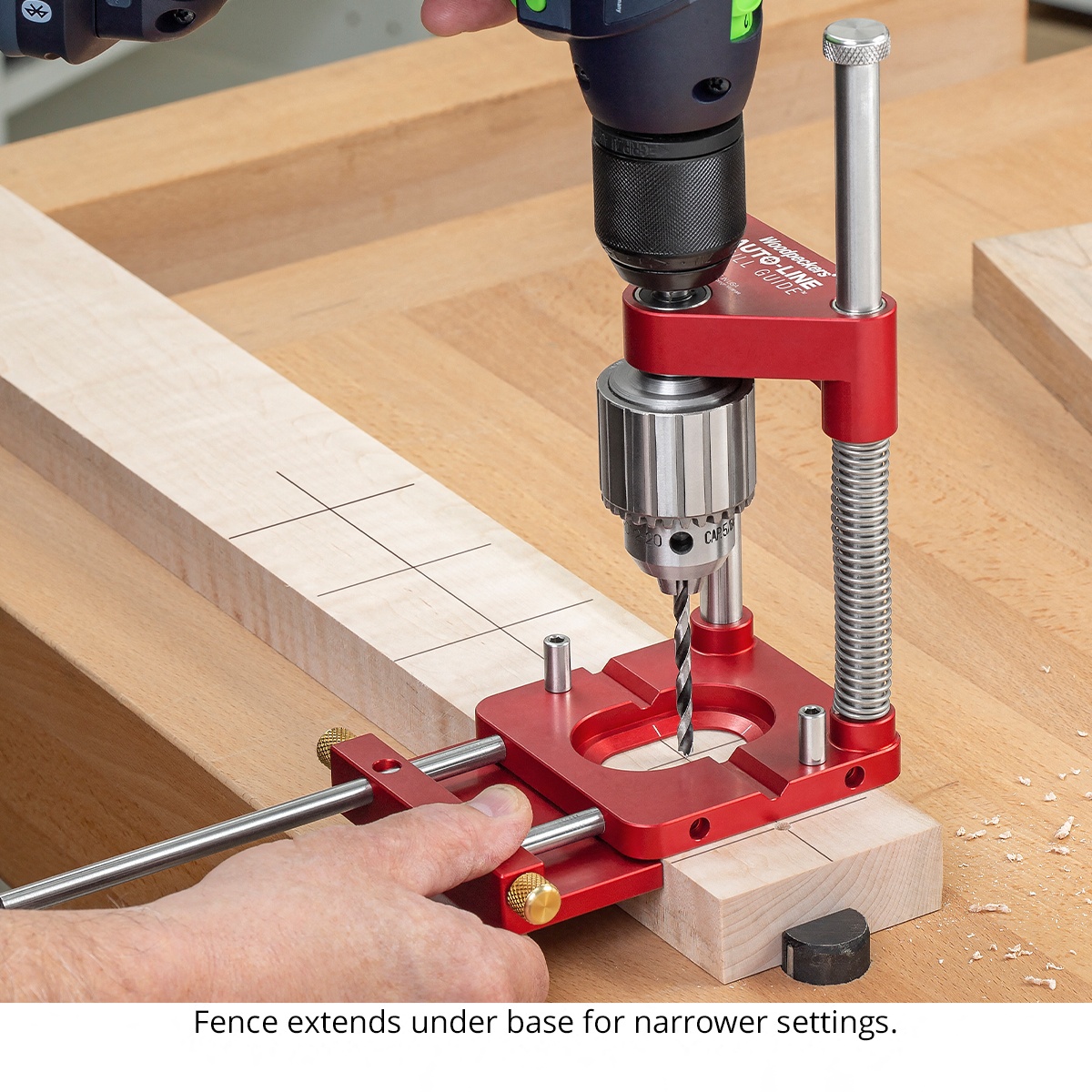 Woodpeckers ALDG-21 Auto-Line Drill Guide drilling a narrow wood board with the fence extended under the base on a woodworking bench