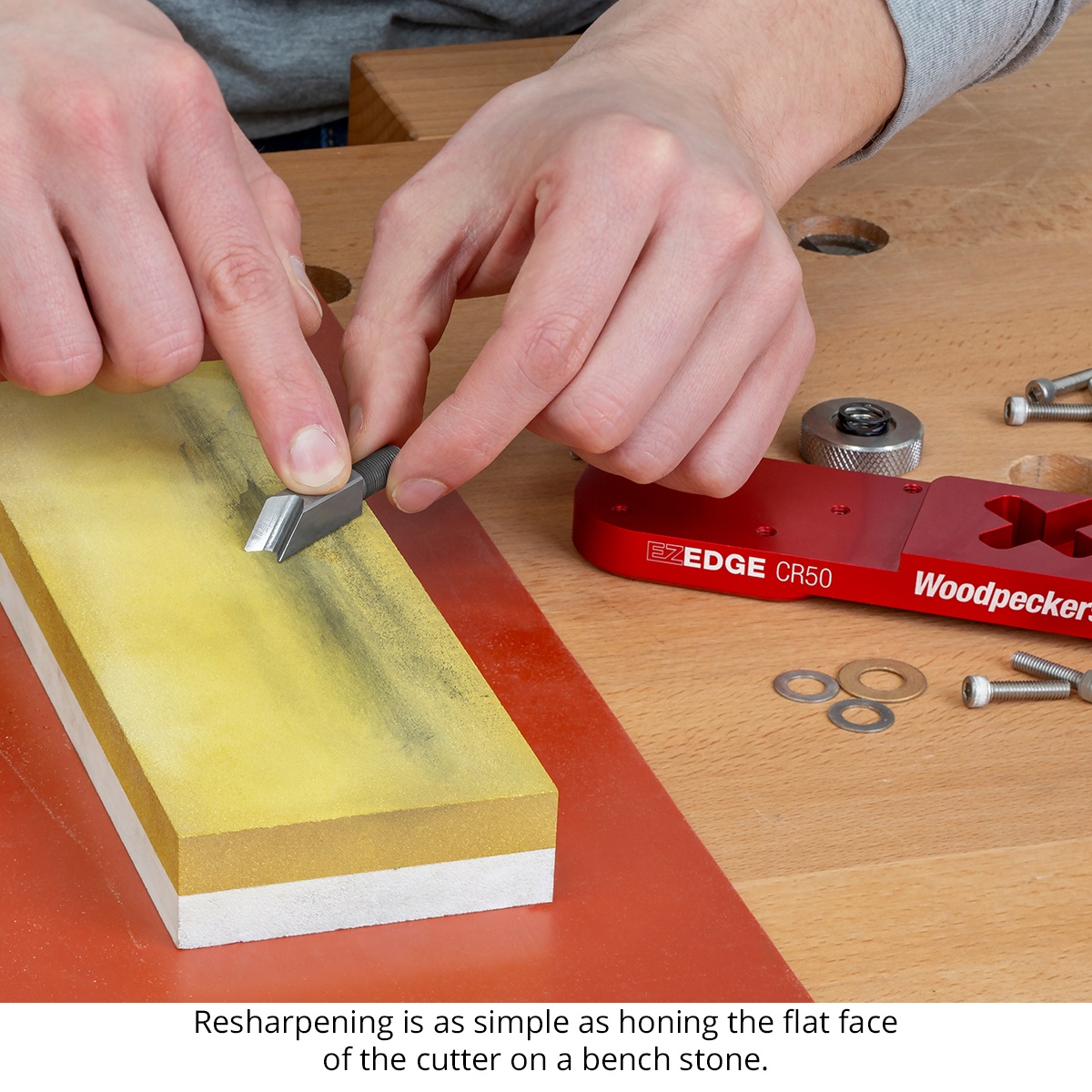 Woodpeckers EZ Edge Corner Plane cutter being honed on a bench stone at a workbench for sharpening and maintenance