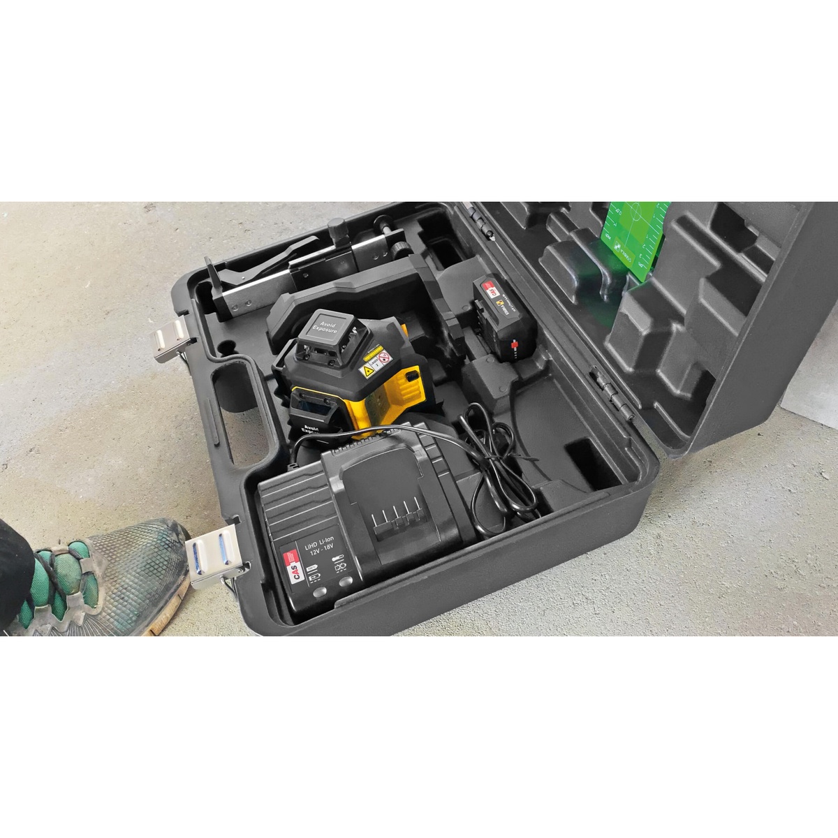 Stabila cordless kit case with Stabila 07621 Battery Charger stored alongside battery-powered layout equipment on a concrete floor jobsite