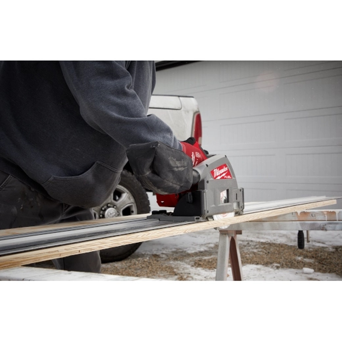Milwaukee Guide Rail Connector used with a Milwaukee track saw making a long cut on a plywood sheet at a jobsite work stand