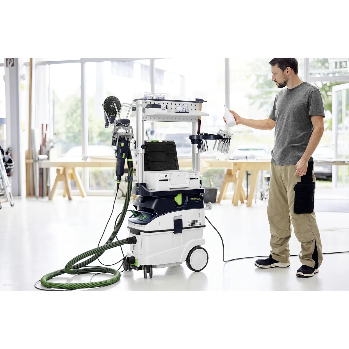 Festool 577253 CT Workcenter WCR-1000 mounted on a Festool CT dust extractor in a bright workshop with tools and supplies organized for sanding and finishing work