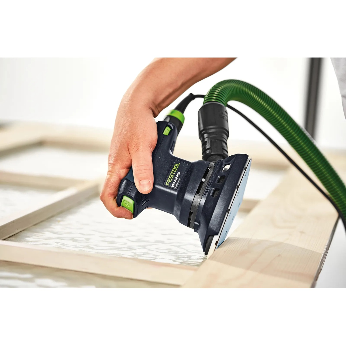 Festool DTS 400 REQ-Plus Finish Delta Sander sanding along a wood frame edge on a workbench during detail finish prep