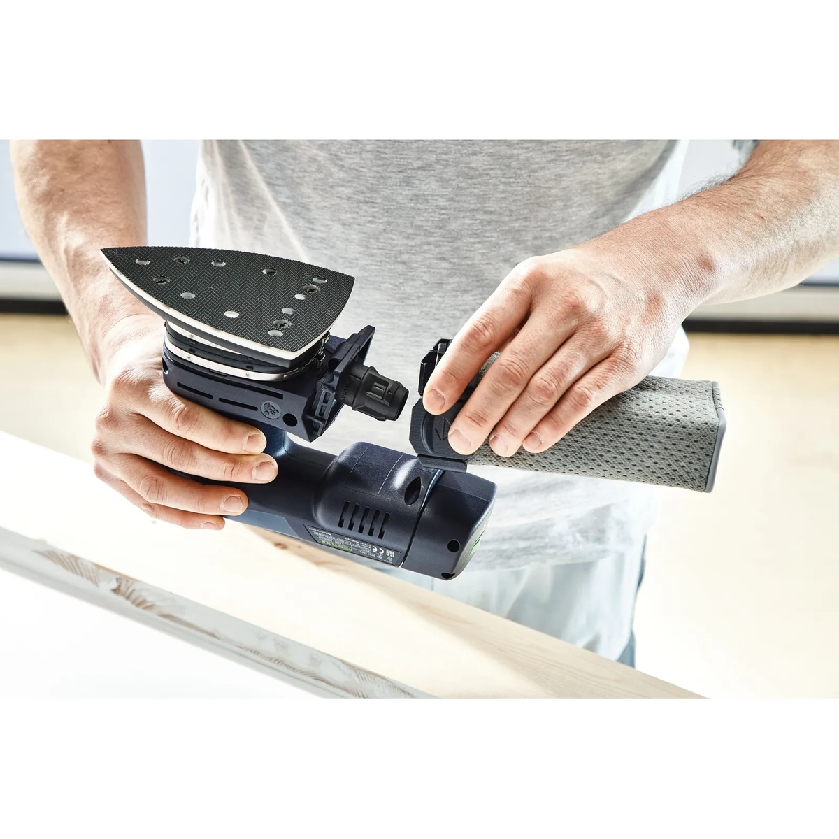 Festool 577530 DTS 400 StickFix Replacement Sanding Pad, Soft, 100 X 150mm (4 x 6 in) installed on a detail sander for sanding wood trim at a workbench